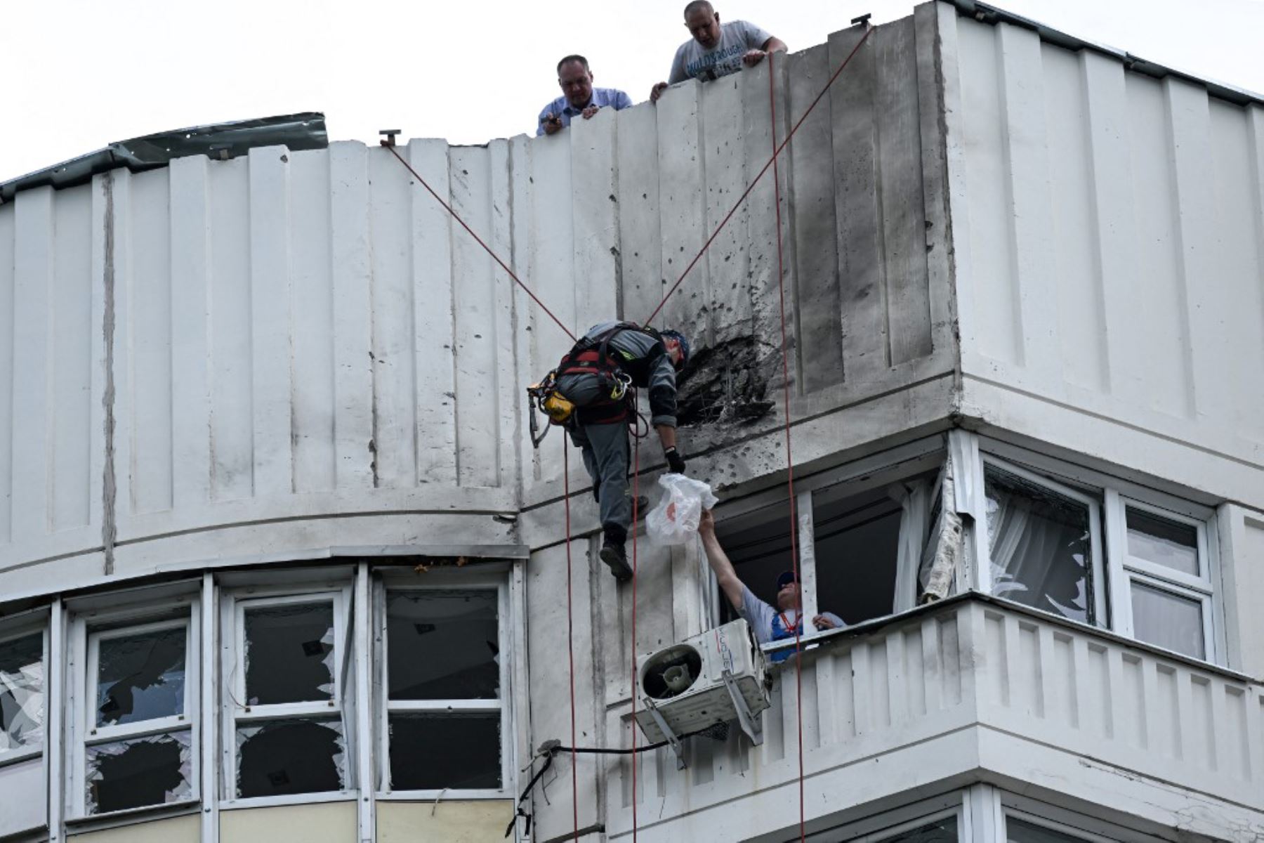 Un especialista inspecciona la fachada dañada de un edificio de apartamentos de varios pisos después de un ataque con drones en Moscú el 30 de mayo de 2023. Foto: AFP