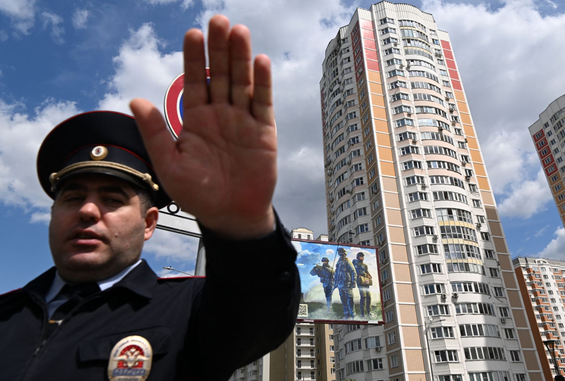 Un oficial de policía asegura un área fuera de un edificio de apartamentos de varios pisos dañado después de un ataque con drones en Moscú el 30 de mayo de 2023.
Foto: AFP