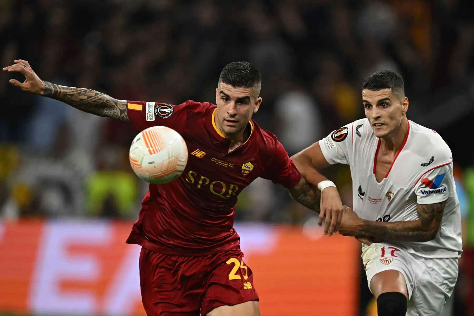 El defensa italiano del AS Roma, Gianluca Mancini (izquierda), y el delantero argentino del Sevilla, Erik Lamela, disputan el balón durante el partido de fútbol final de la UEFA Europa League entre el Sevilla FC y el AS Roma en el Puskas Arena de Budapest, Hungría, el 31 de mayo de 2023.

Foto: AFP