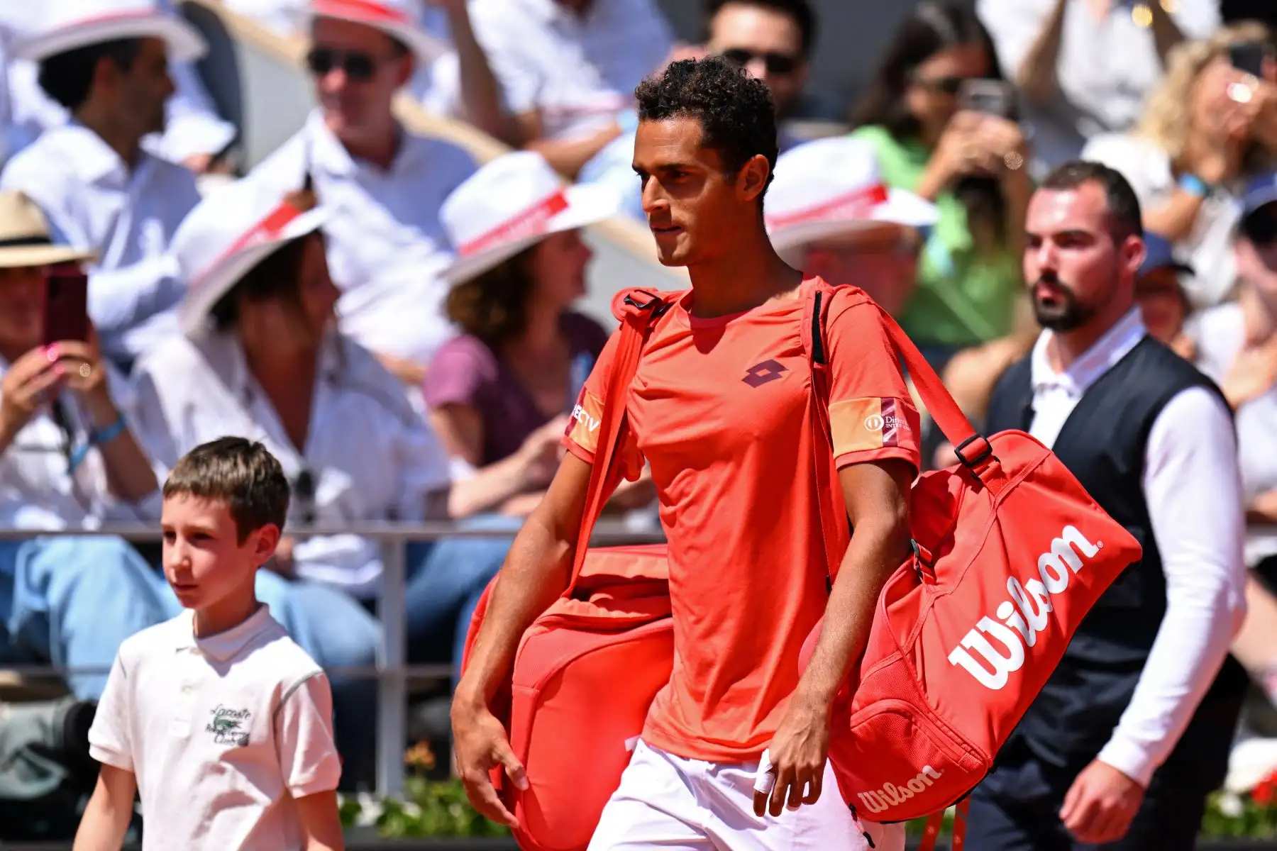 El peruano Juan Pablo Varillas (centro) llega a la cancha para jugar contra el serbio Novak Djokovic durante su partido individual masculino el octavo día del torneo de tenis Roland-Garros Open en la Court Philippe-Chatrier de París el 4 de junio de 2023.

Foto: AFP