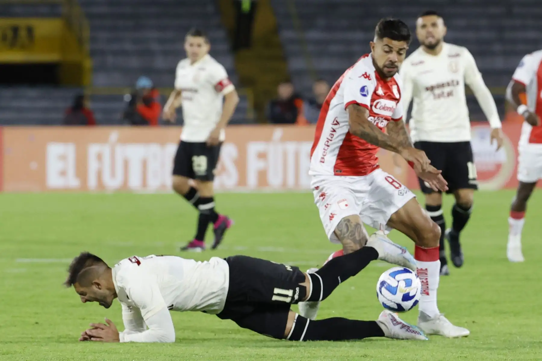 Jonathan Barboza de Santa Fe disputa el balón con Luis Urruti de Universitario hoy, en un partido de la fase de grupos de la Copa Sudamericana entre Independiente Santa Fe y Universitario en el estadio El Campín en Bogotá
Foto: EFE