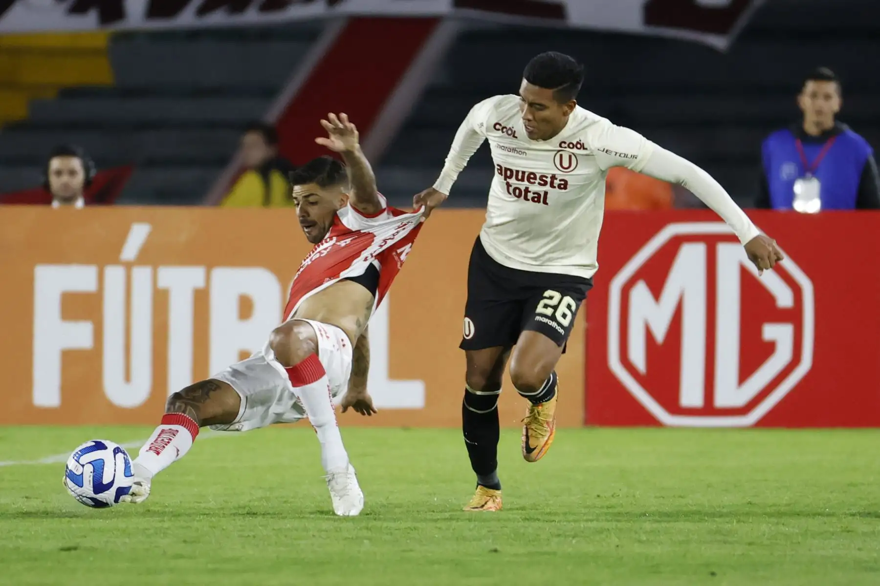 Jonathan Barboza de Santa Fe disputa el balón con Hugo Ancajima de Universitario hoy, en un partido de la fase de grupos de la Copa Sudamericana entre Independiente Santa Fe y Universitario en el estadio El Campín en Bogotá.
Foto: EFE