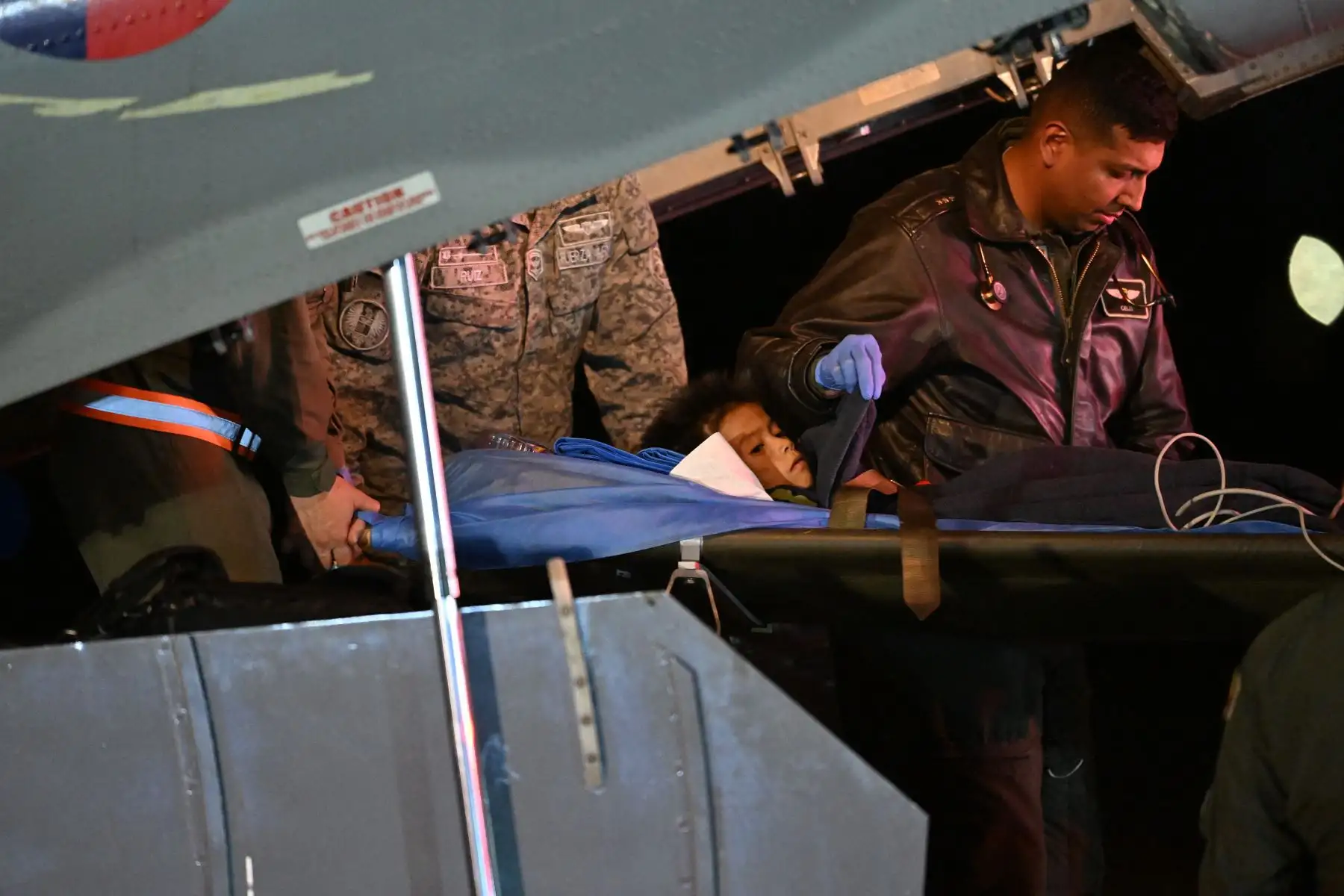 Uno de los cuatro niños indígenas que fueron encontrados con vida después de haber estado perdido durante 40 días en la selva amazónica colombiana luego de un accidente aéreo, es sacado en camilla de un avión al aterrizar en la base militar de CATAM en Bogotá.
Foto: AFP