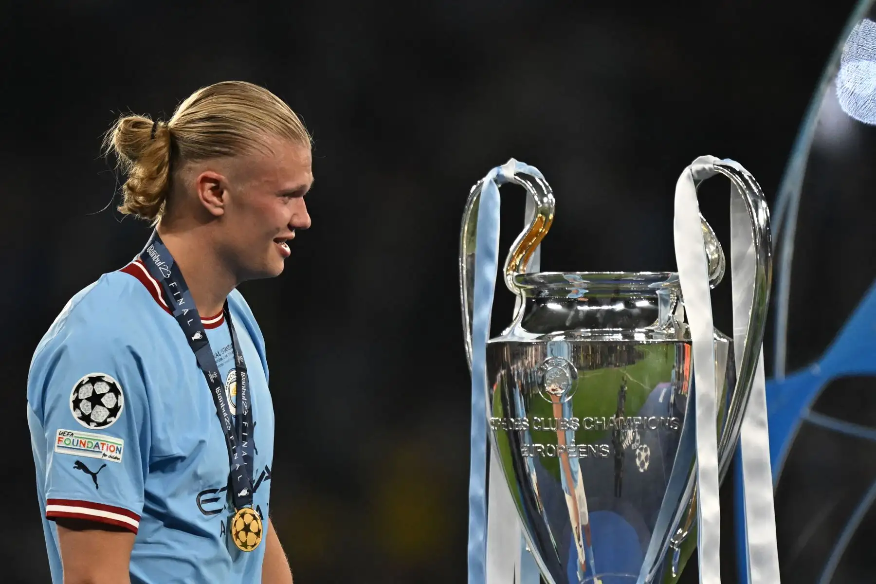 El delantero noruego # 9 del Manchester City, Erling Haaland, pasa junto al trofeo de la Copa de Europa mientras celebran ganar el partido de fútbol final de la Liga de Campeones de la UEFA entre el Inter de Milán y el Manchester City en el Estadio Olímpico Ataturk en Estambul, el 10 de junio de 2023. El Manchester City ganó el partido 1-0.
Foto: AFP