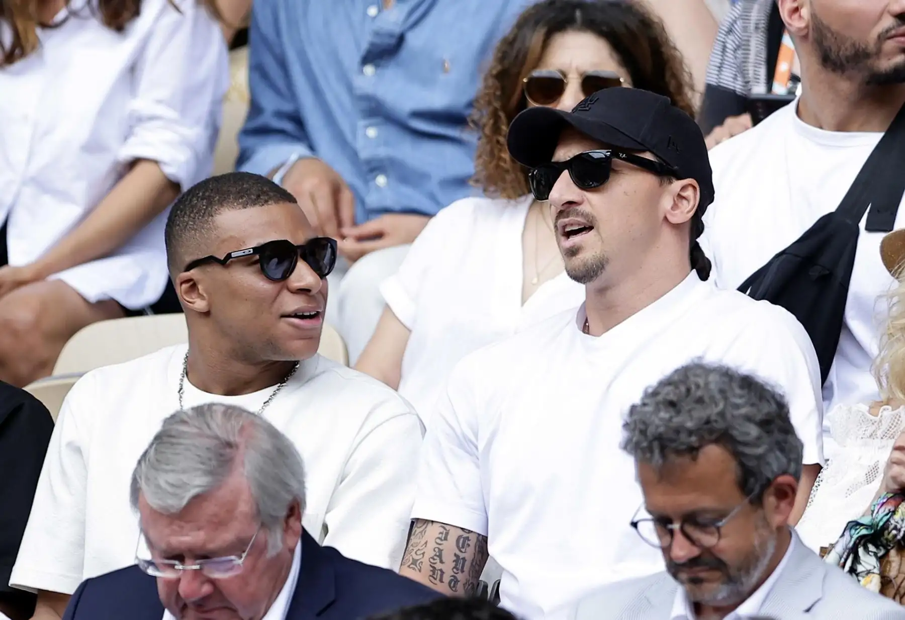 El futbolista francés Kylian Mbappe (L) y el futbolista sueco Zlatan Ibrahimovic (R) asisten a la final de Men