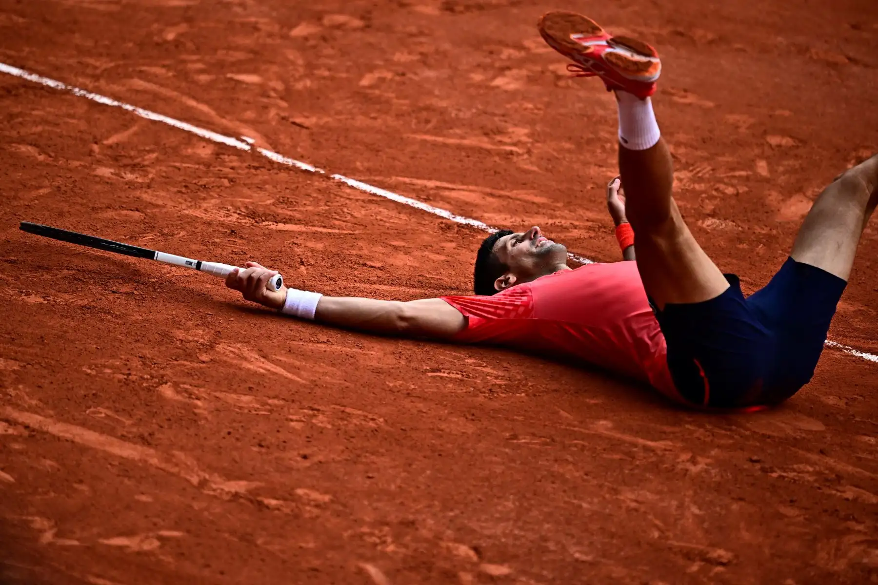 El serbio Novak Djokovic descansa en la cancha mientras celebra su victoria sobre el noruego Casper Ruud durante el partido final individual masculino el día quince del torneo de tenis Roland-Garros Open en la Court Philippe-Chatrier de París el 11 de junio de 2023.
Foto: AFP