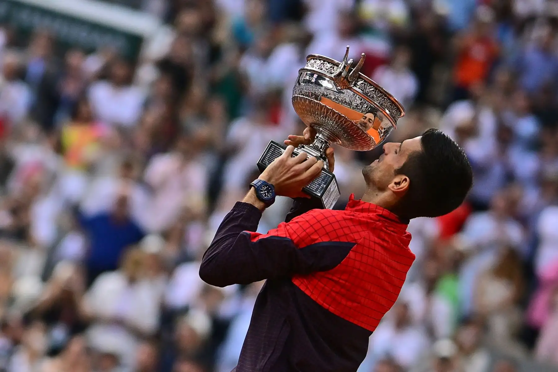 El serbio Novak Djokovic levanta su trofeo mientras celebra su victoria sobre el noruego Casper Ruud durante el partido final individual masculino del día quince del torneo de tenis Roland-Garros Open en la Court Philippe-Chatrier de París el 11 de junio de 2023.
Foto: AFP