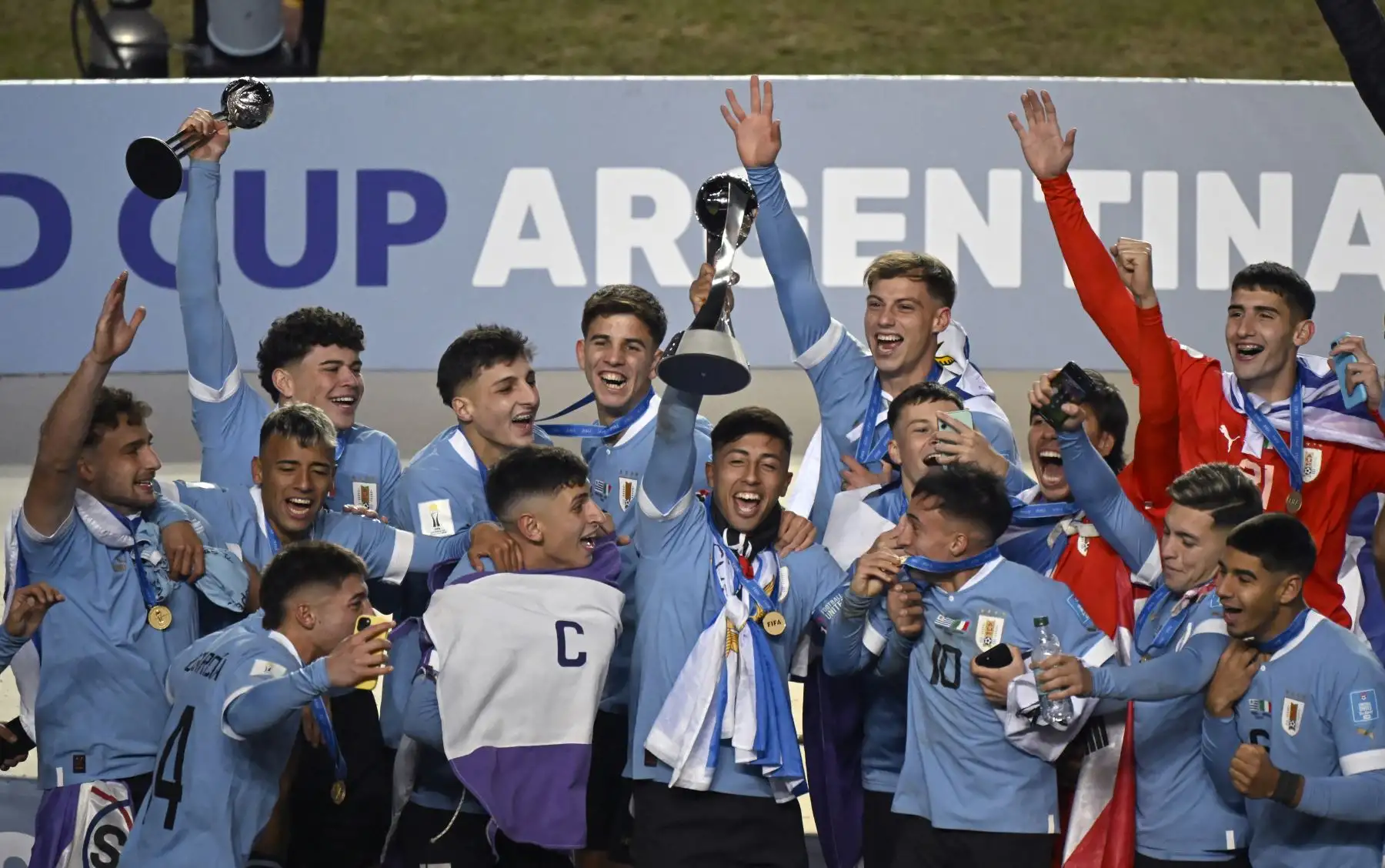 El mediocampista uruguayo Fabricio Díaz sostiene el trofeo junto con sus compañeros de equipo después de derrotar a Italia y ganar la Copa Mundial Sub-20 Argentina 2023 en el Estadio Unico Diego Armando Maradona en La Plata, Argentina.
Foto: AFP