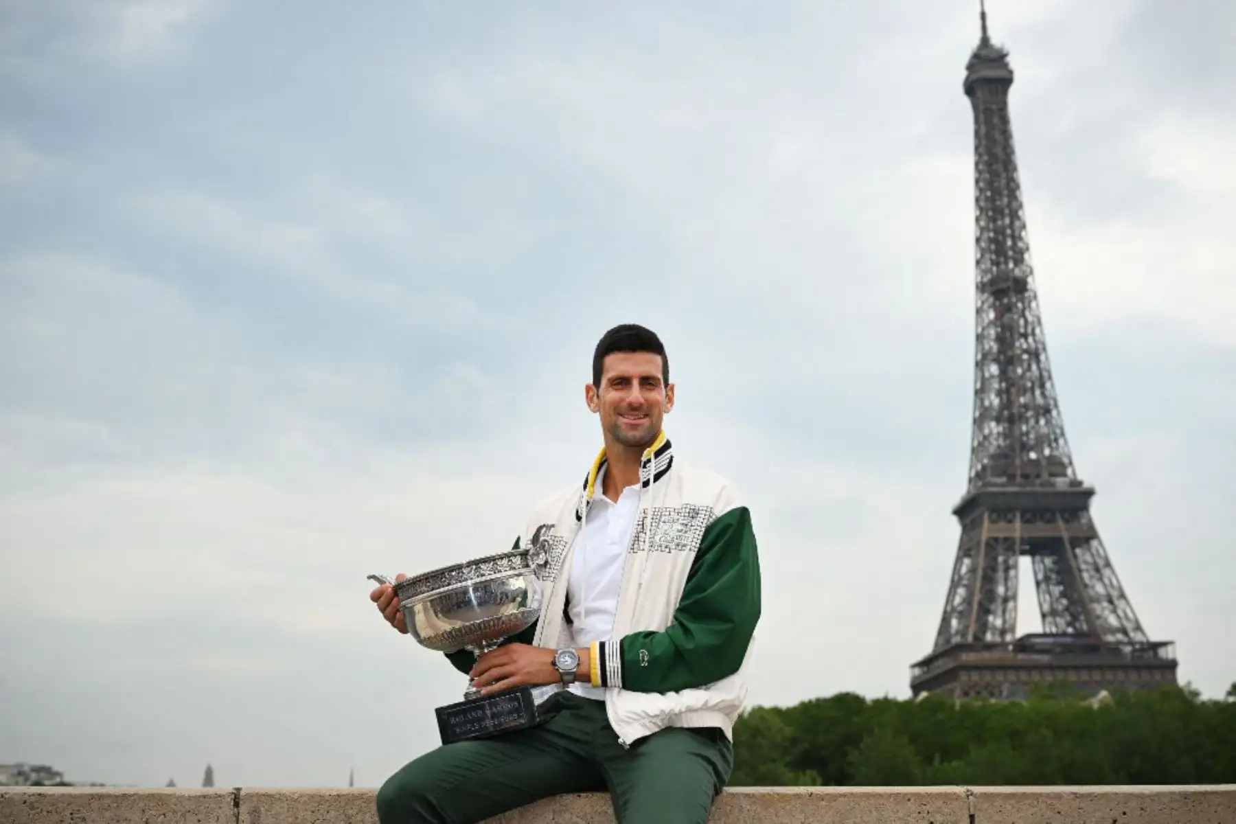 El serbio Novak Djokovic posa con el Trofeo de los Mosqueteros, mientras la Torre Eiffel se ve al fondo, durante una sesión de fotos después de ganar el torneo de tenis Roland Garros French Open, en París. Foto: AFP