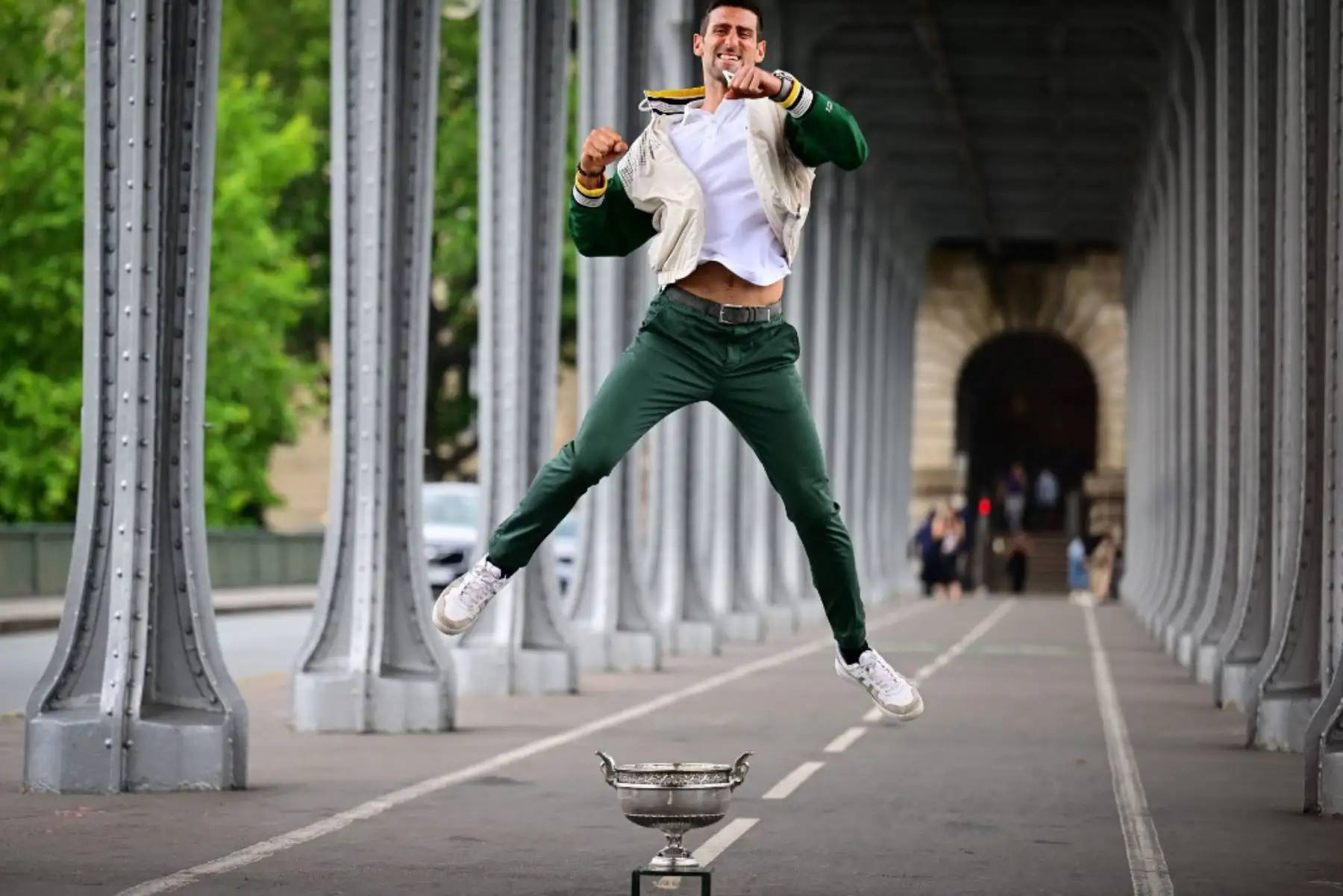 El serbio Novak Djokovic, salta sobre el Trofeo de los Mosqueteros, durante una sesión de fotos después de ganar el torneo de tenis Roland Garros French Open, en París. Foto: AFP