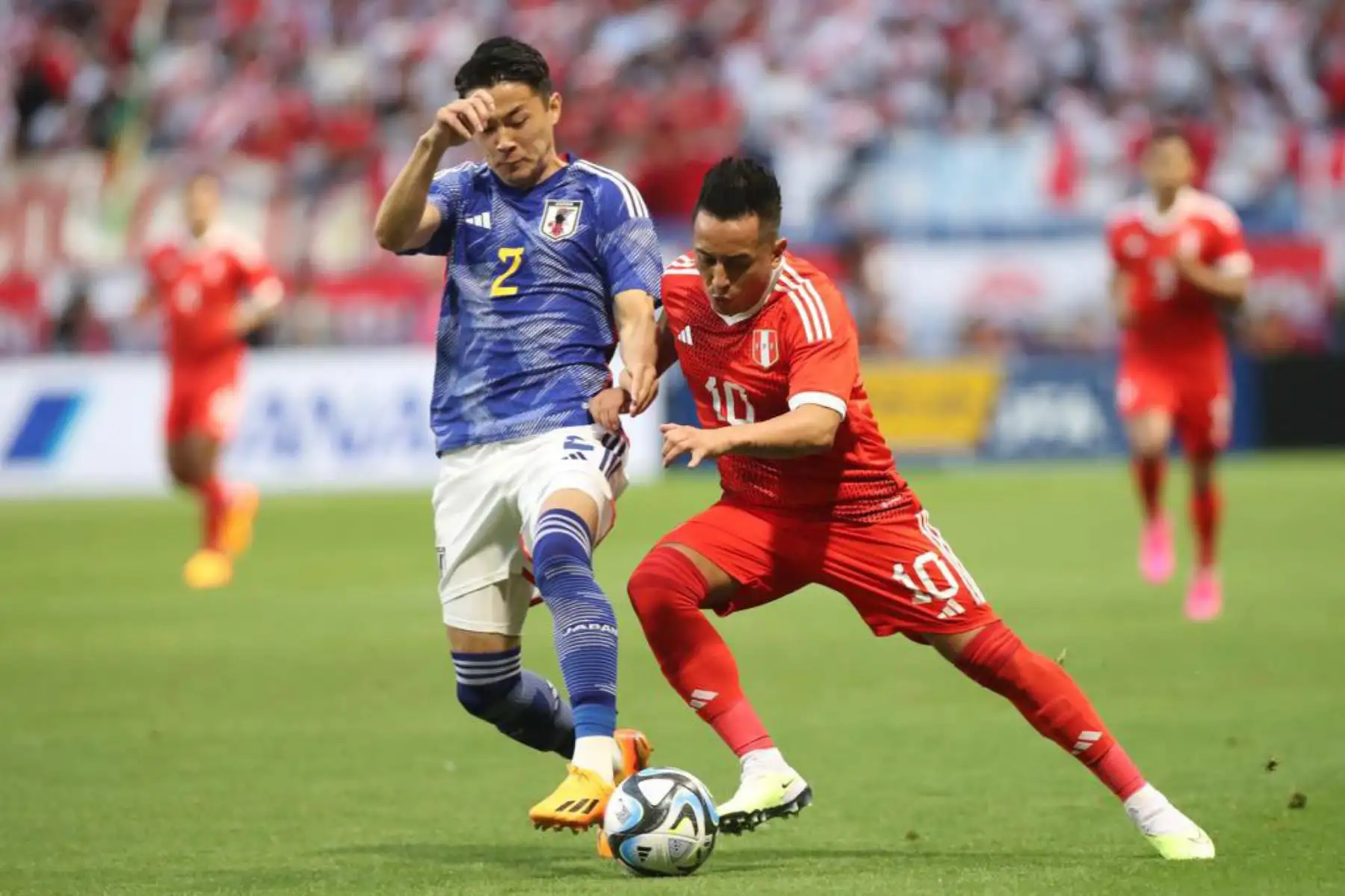 Christian Cueva de la selección peruana disputa la pelota con un futbolista de selección de Japón en el Panasonic Staddium Suita. Foto: ANDINA/ FPF
