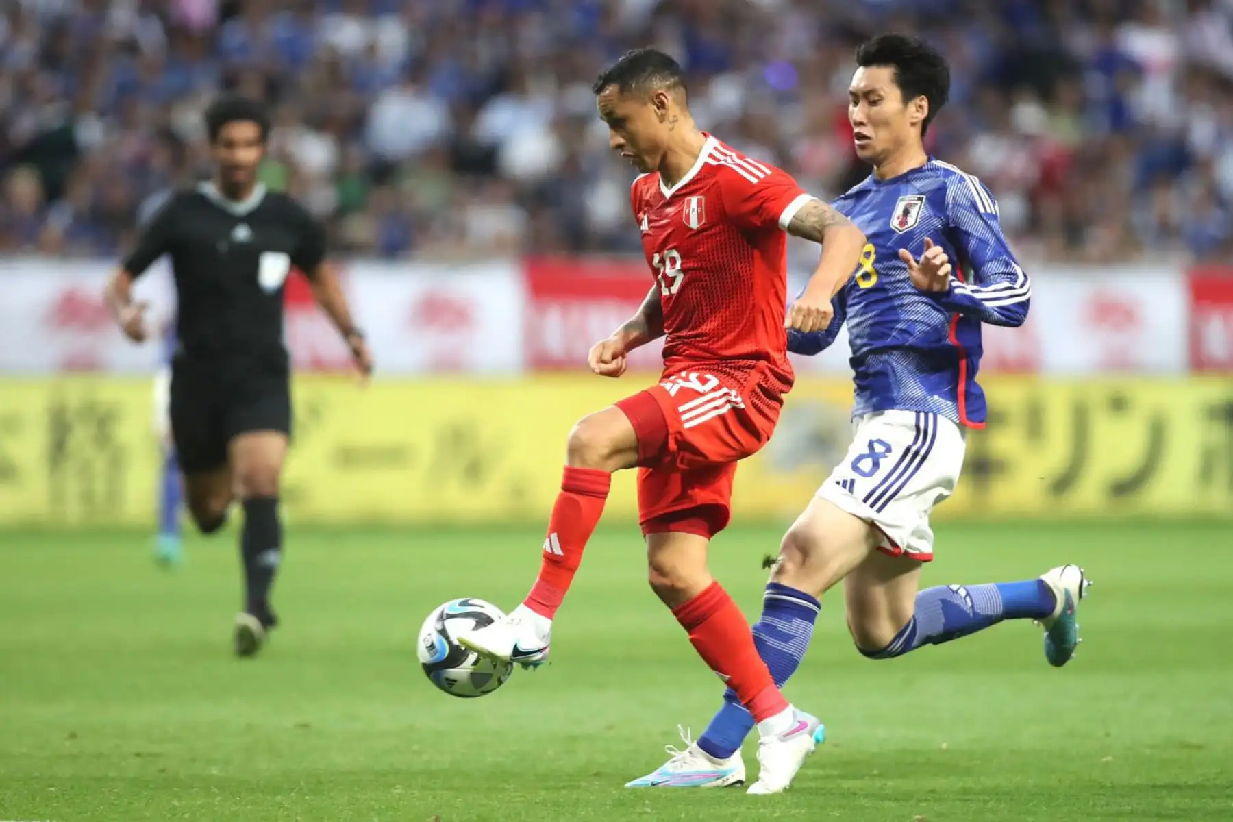 Yoshimar Yotún de la selección peruana disputa la pelota con un futbolista de selección de Japón en el Panasonic Staddium Suita. Foto: ANDINA/ FPF