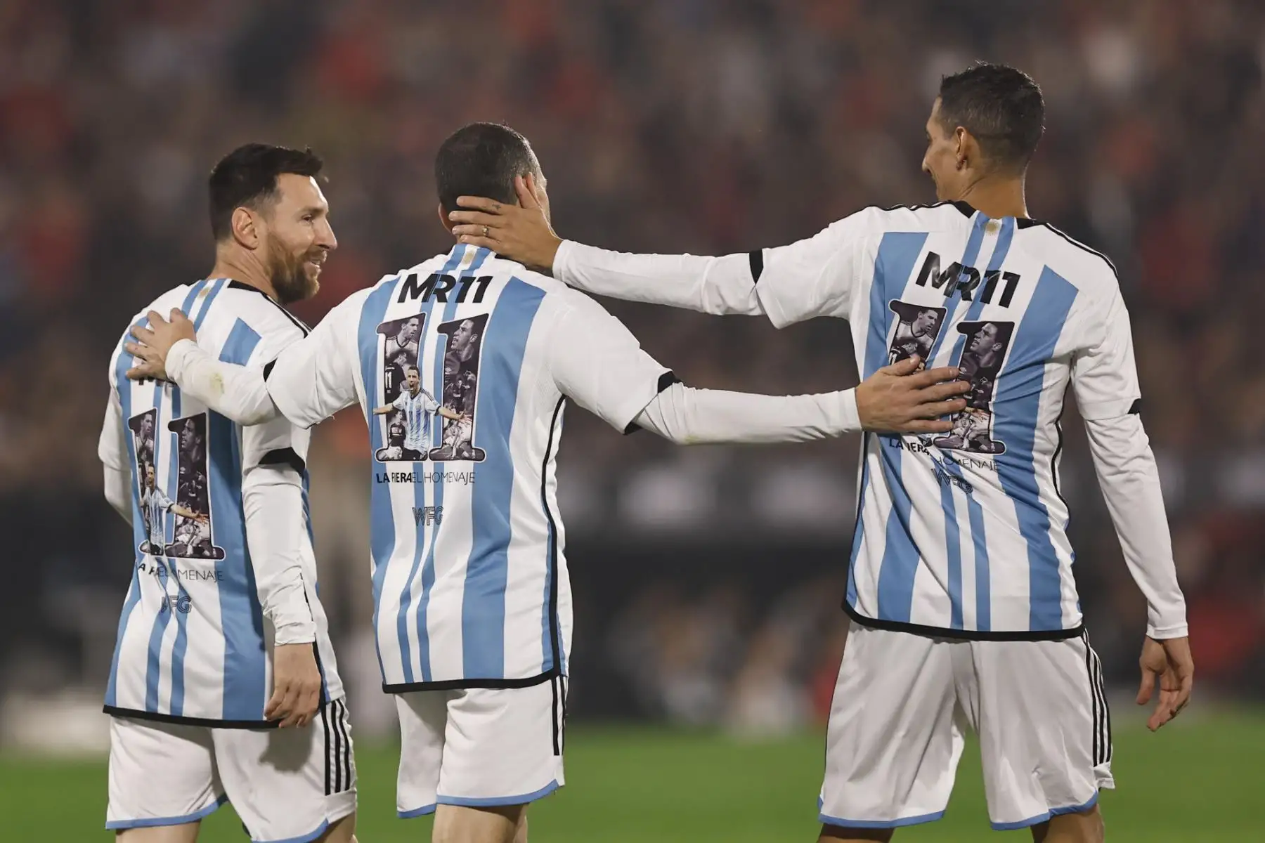 Los argentinos Lionel Messi (i) y Ángel di María (d) acompañan a Maxi Rodríguez (c) hoy, en su partido de despedida en el estadio Coloso Marcelo Bielsa en Rosario (Argentina). Foto: EFE