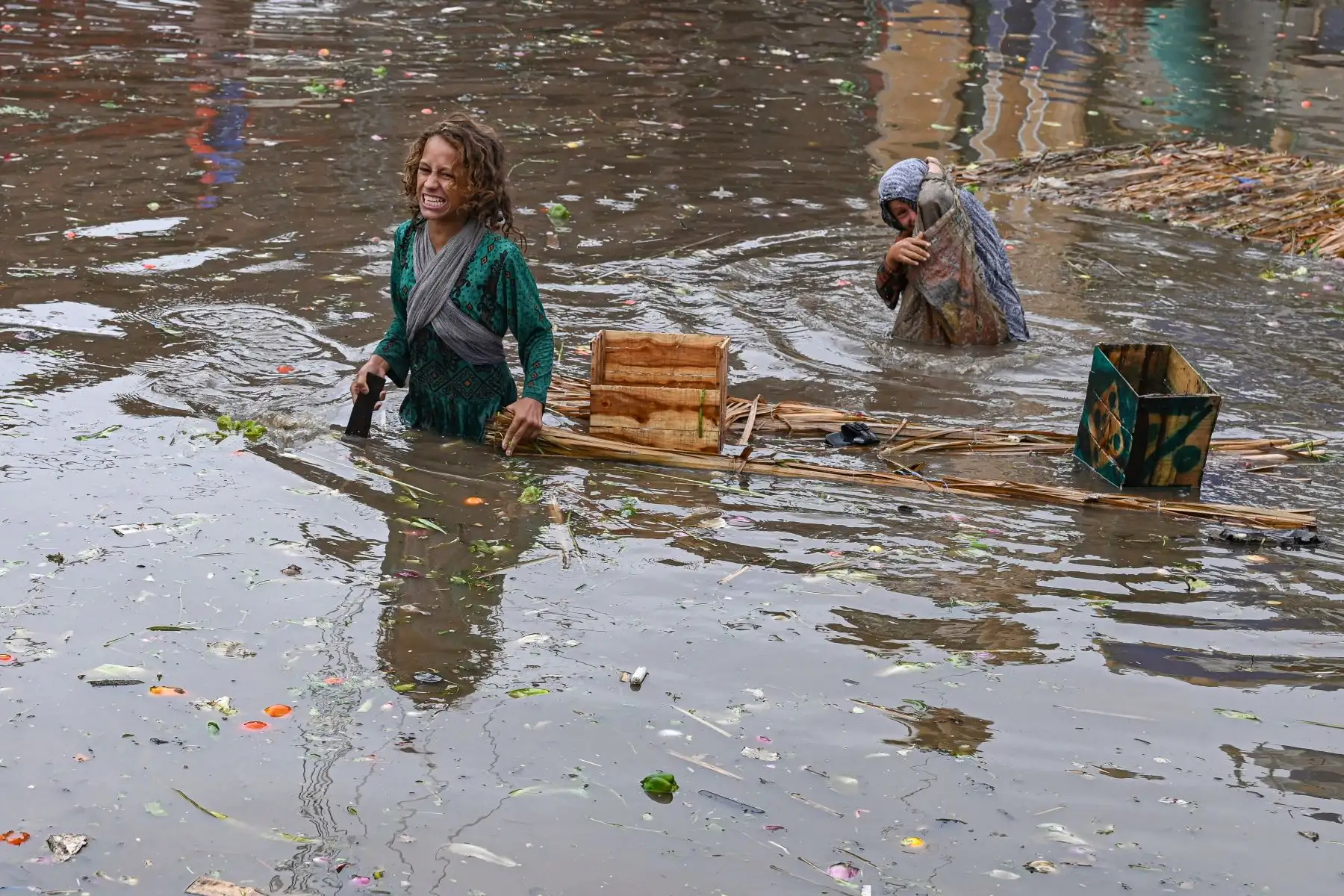 Los niños recogen verduras del agua en un mercado inundado después de fuertes lluvias en Lahore.
Foto: AFP