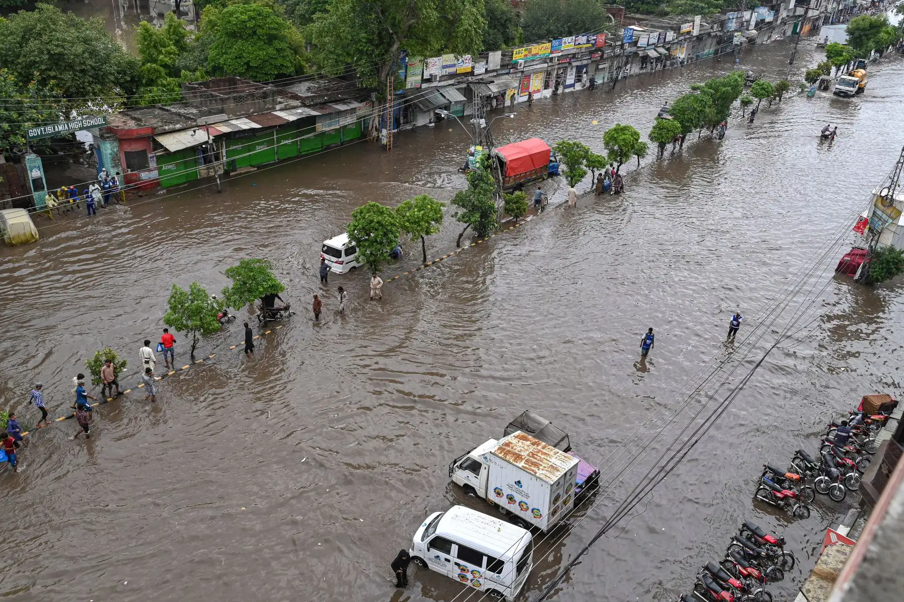 La gente se abre paso a través de un camino inundado después de una fuerte lluvia en Lahore.
Foto: AFP