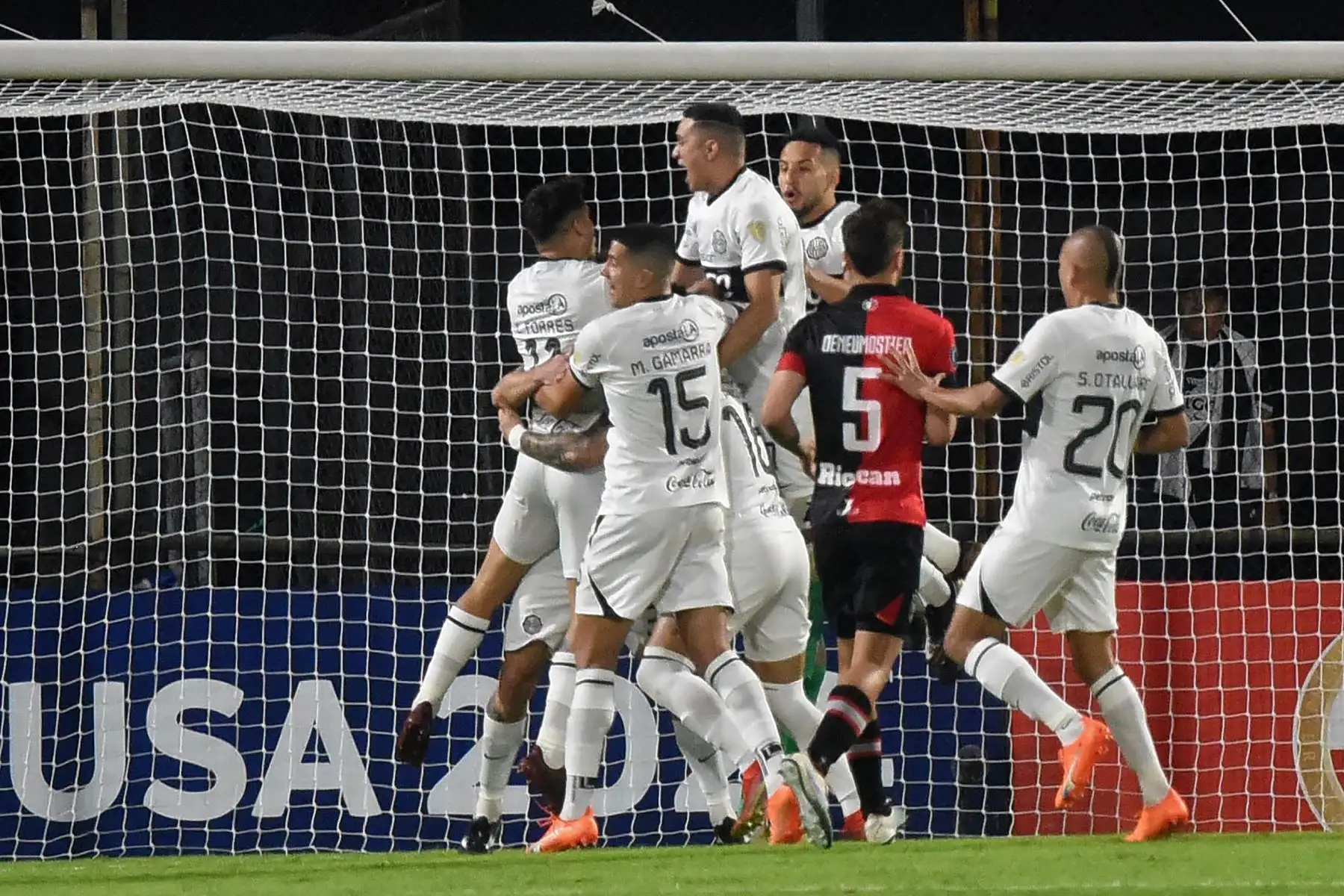 El mediocampista uruguayo de Olimpia Alejandro Silva (cubierto) celebra con sus compañeros de equipo después de anotar durante el partido de vuelta de la fase de grupos de la Copa Libertadores entre Olimpia de Paraguay y Melgar de Perú en el estadio Manuel Ferreira en Asunción, el 27 de junio de 2023.
Foto: AFP
