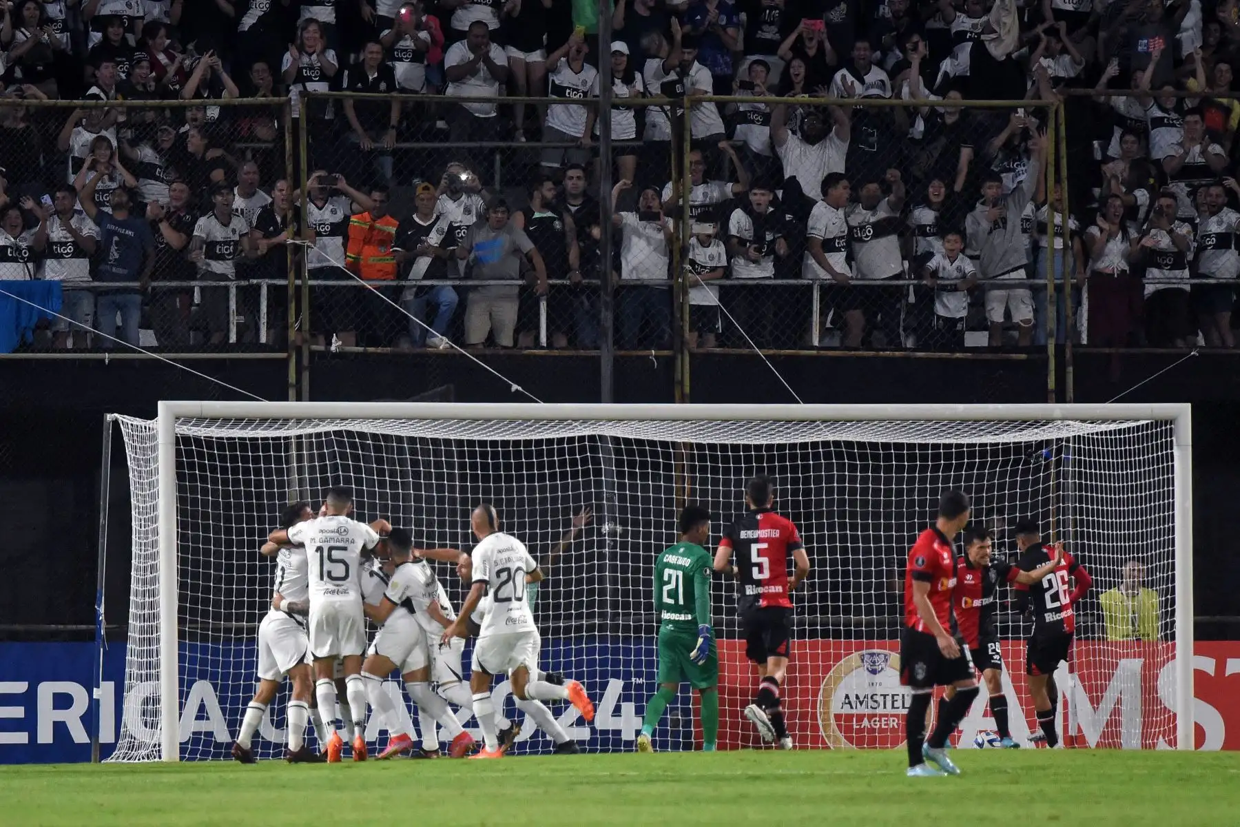 El mediocampista uruguayo de Olimpia Alejandro Silva (cubierto) celebra con sus compañeros de equipo después de anotar durante el partido de vuelta de la fase de grupos de la Copa Libertadores entre Olimpia de Paraguay y Melgar de Perú en el estadio Manuel Ferreira en Asunción, el 27 de junio de 2023.
Foto: AFP