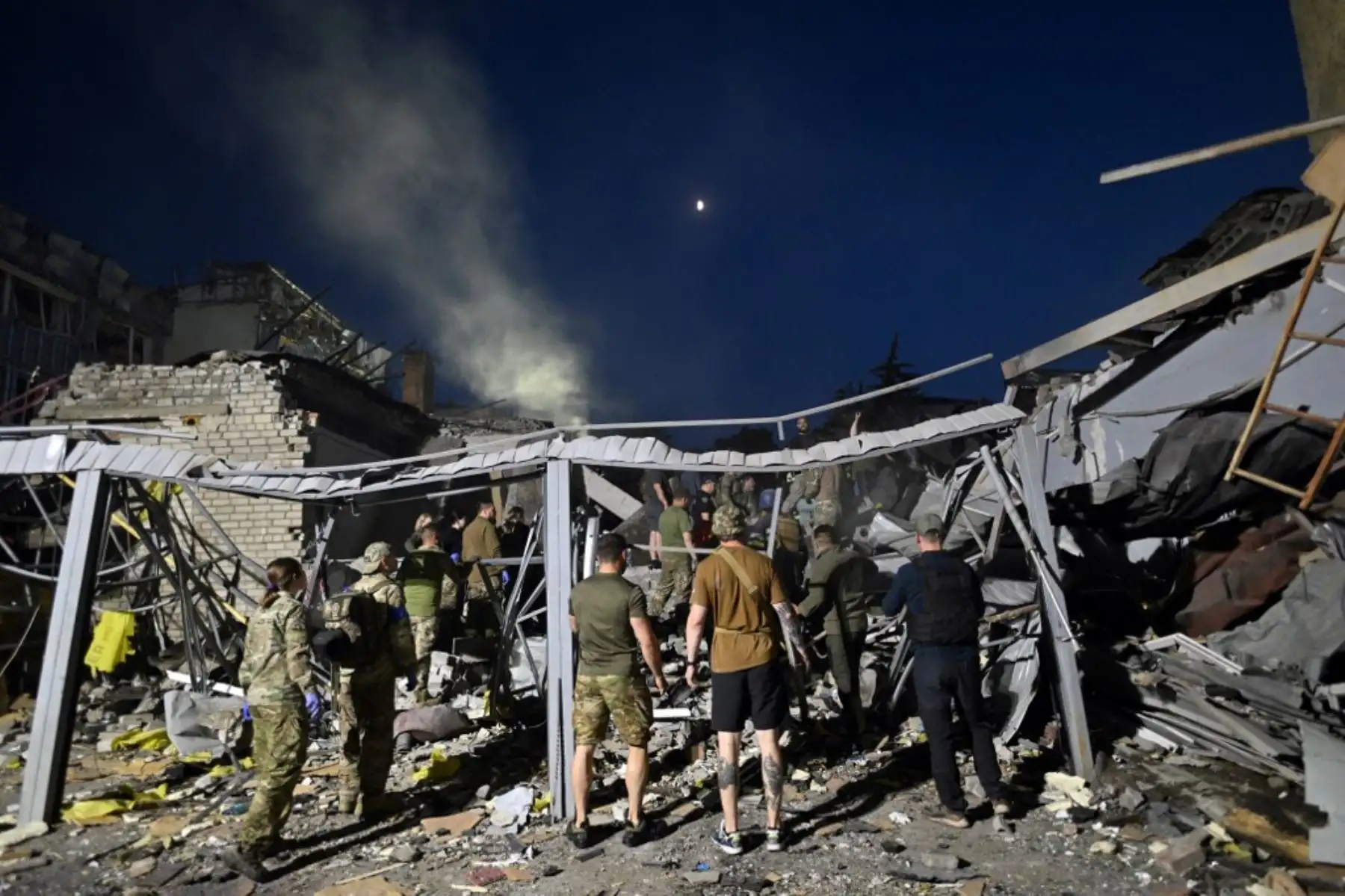 Rescatistas y voluntarios trabajan para rescatar a personas de debajo de los escombros después de que un misil ruso impactara en un restaurante y varias casas en Ucrania. Foto: AFP