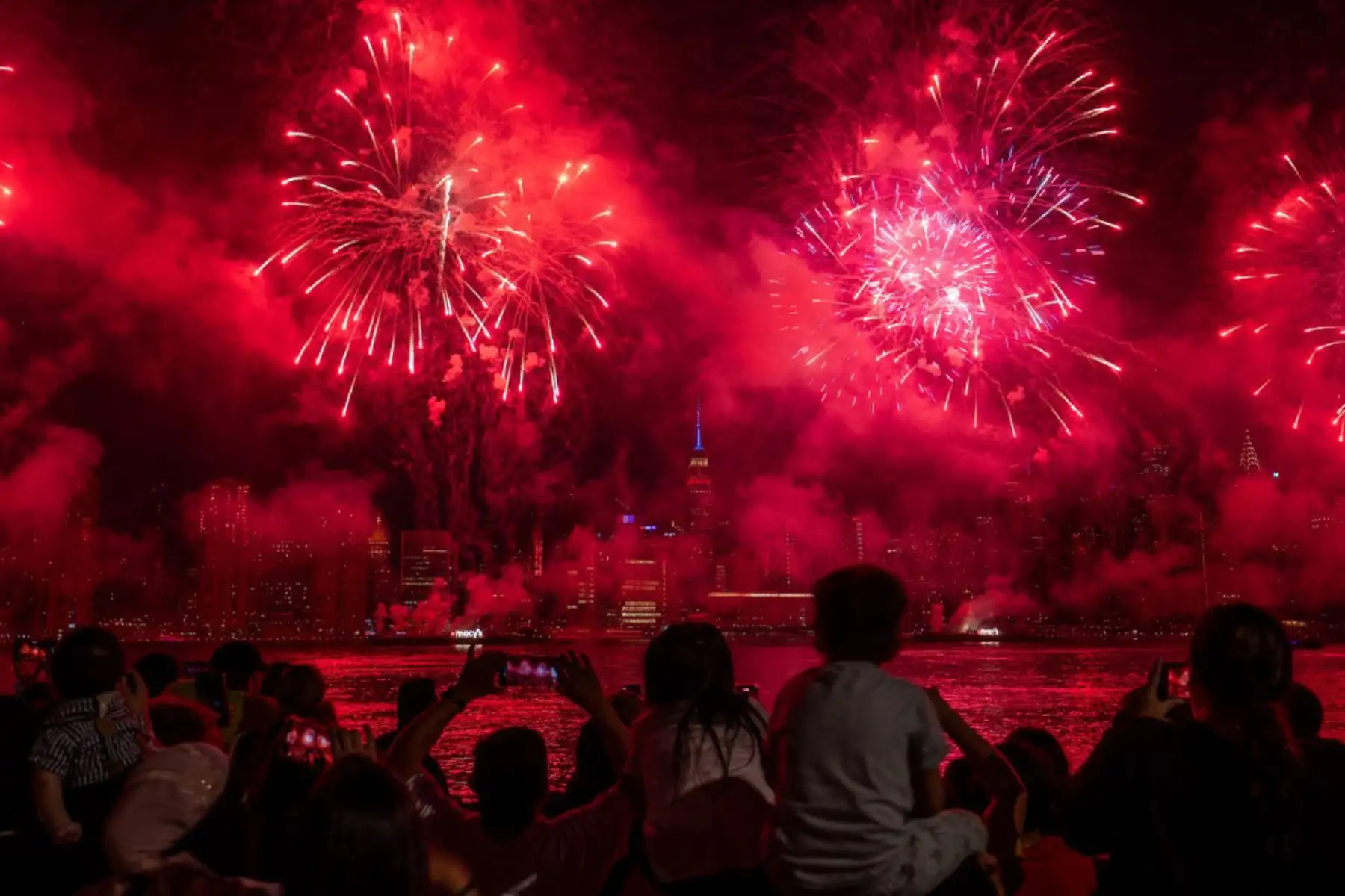 La gente observa cómo estallan los fuegos artificiales sobre el horizonte de Manhattan durante la exhibición de fuegos artificiales del Día de la Independencia de Macy