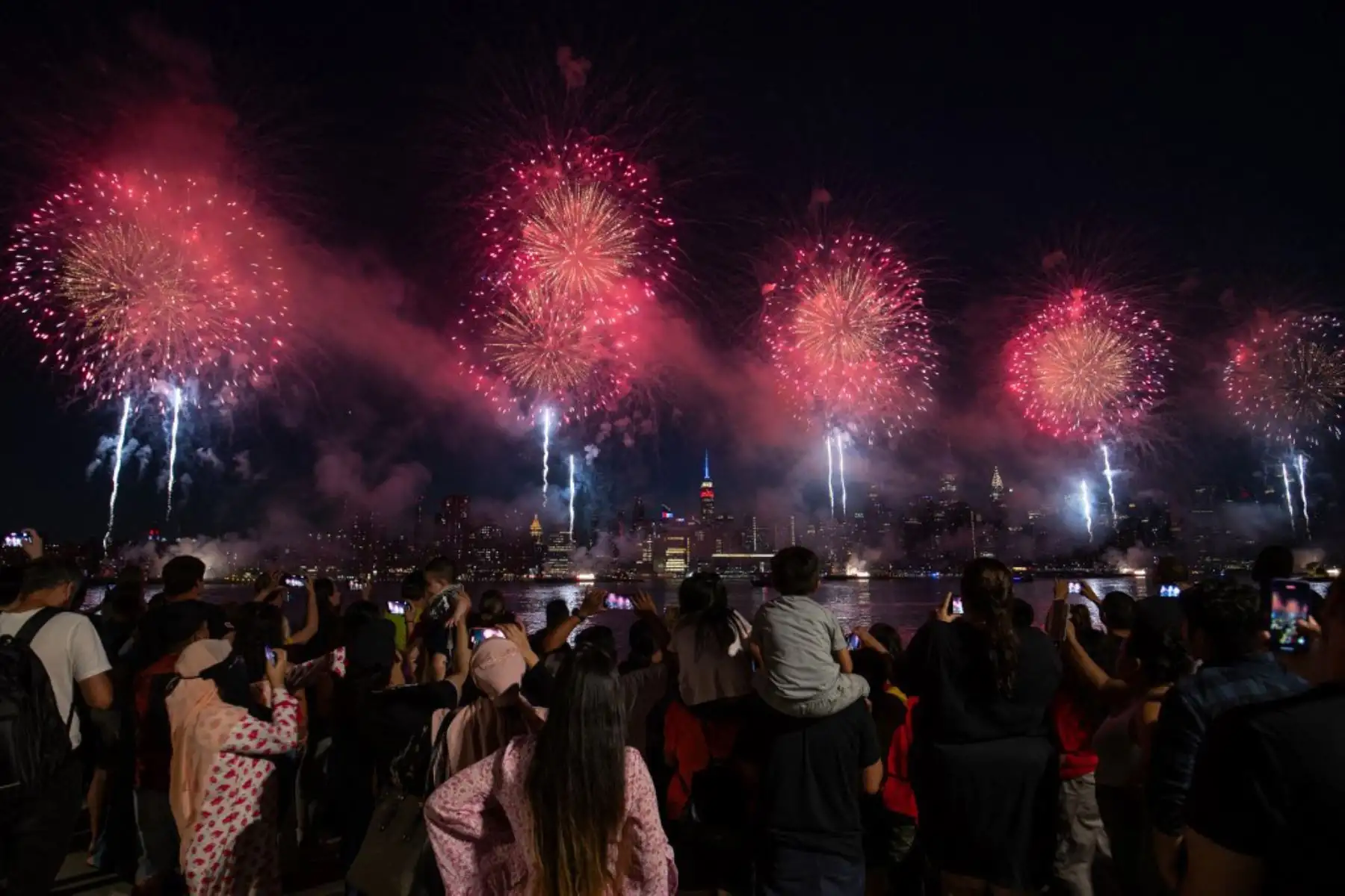 La gente observa cómo estallan los fuegos artificiales sobre el horizonte de Manhattan durante la exhibición de fuegos artificiales del Día de la Independencia de Macy