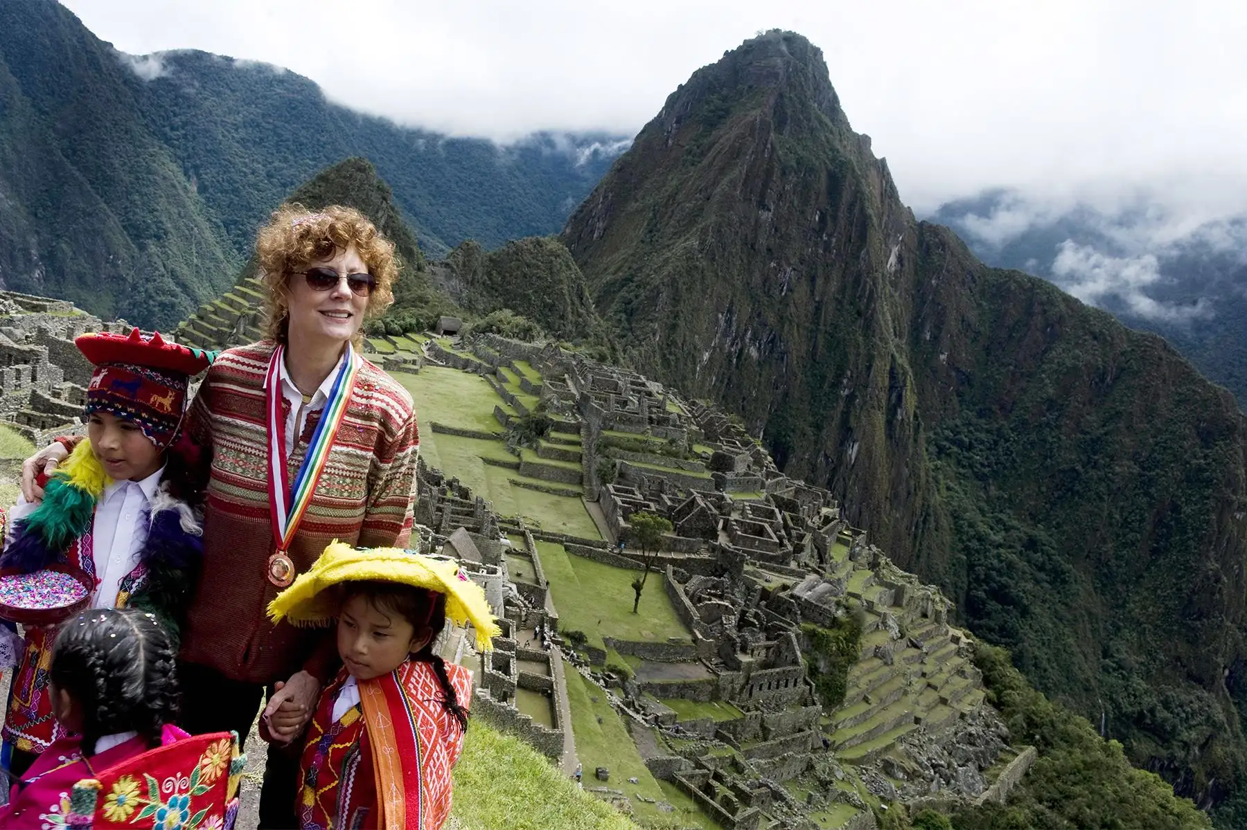 Cusco - 1 abril 2010 / Susan Sarandom posa con niños con atuendos típicos a su llegada al sitio arqueológico de Machu Picchu. La reapertura formal de la antigua ciudadela inca se llevó a cabo el jueves, de la mano de la actriz de Hollywood Sarandon. La ciudadela ubicada a unos 2.500 metros  sobre el nivel del mar, es el sitio más visitado de América del Sur. Foto AFP