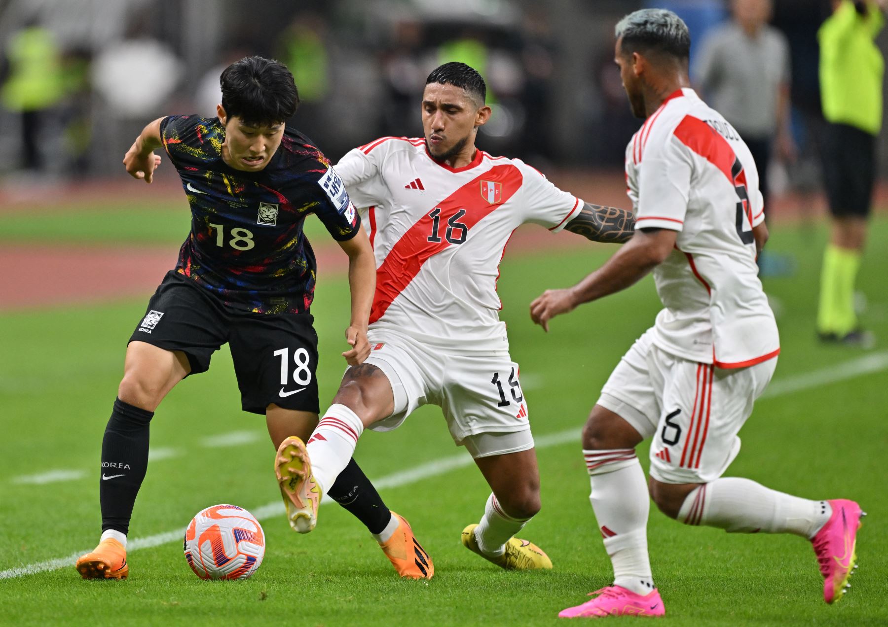 Lee Kang-in (L) de Corea del Sur lucha por el balón con Christofer Gonzales (C) de Perú durante el partido amistoso de fútbol entre Corea del Sur y Perú en el Estadio Busan Asiad en Busan el 16 de junio de 2023.. Foto: AFP