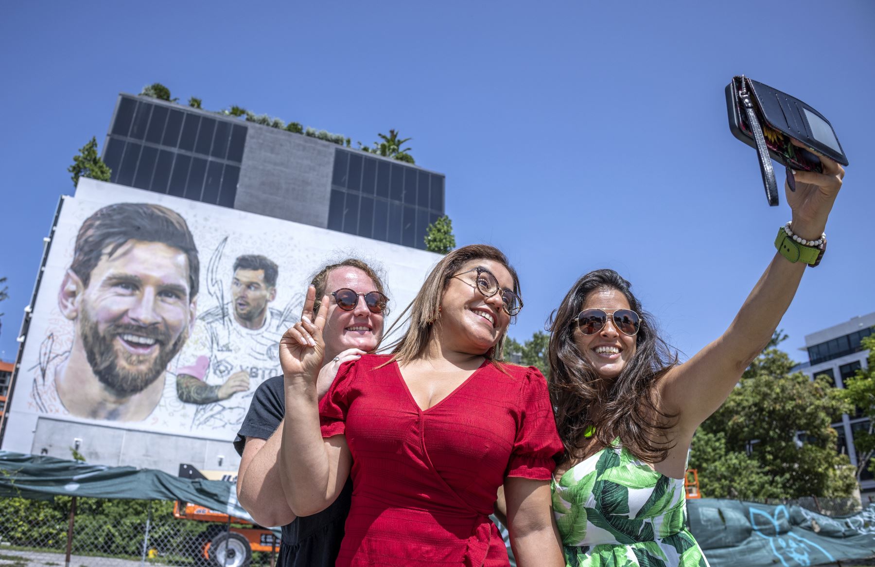 La gente se toma una selfie cerca de un mural del futbolista argentino Lionel Messi que está siendo pintado por el artista argentino Maximiliano Bagnasco en un muro de siete pisos en Wynwood, Florida. 
Foto: EFE
