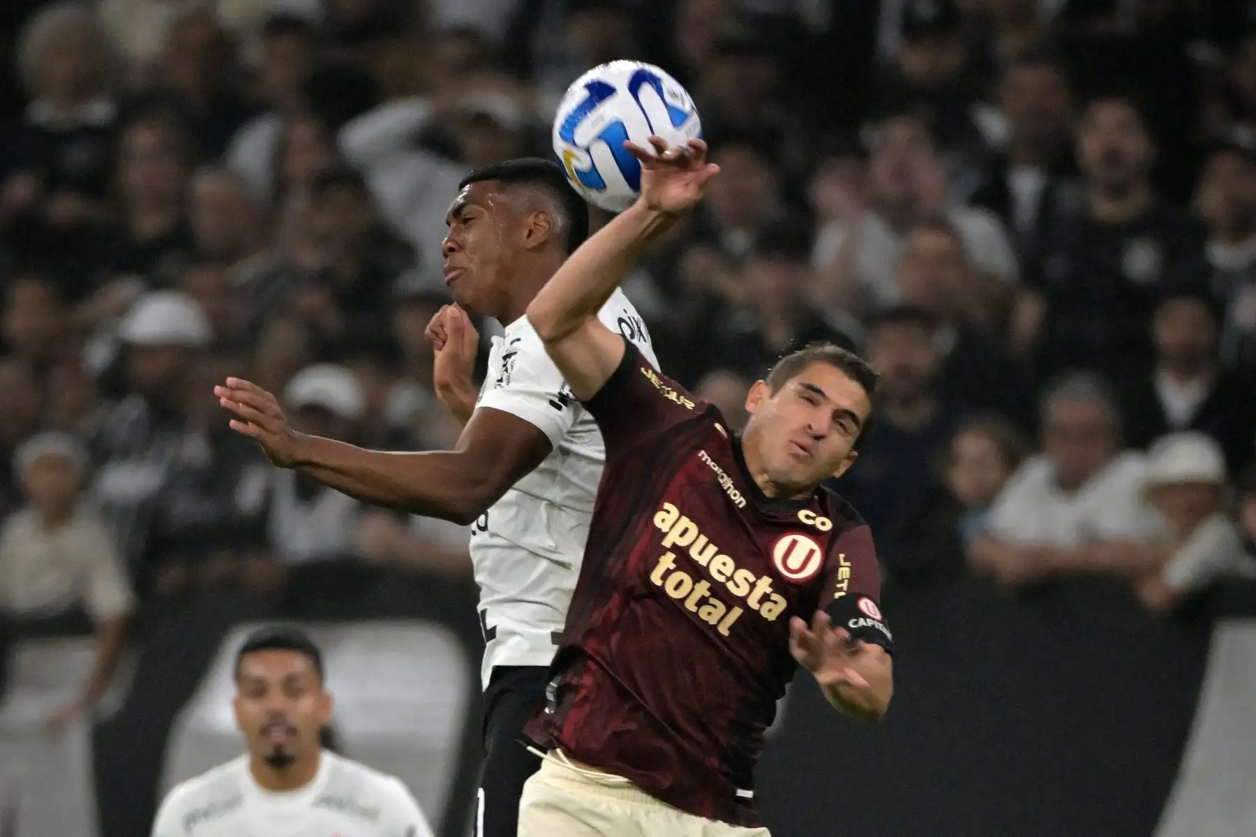 El delantero del Corintios Felipe Augusto y el defensor de Universitario Aldo Corzo saltan por el balón durante el partido de ida de los octavos de final de la Copa Sudamericana entre el Corintios de Brasil y el Universitario de Perú en el Arena Corintios en Sao Paulo, Brasil. Foto:ANDINA/ AFP
