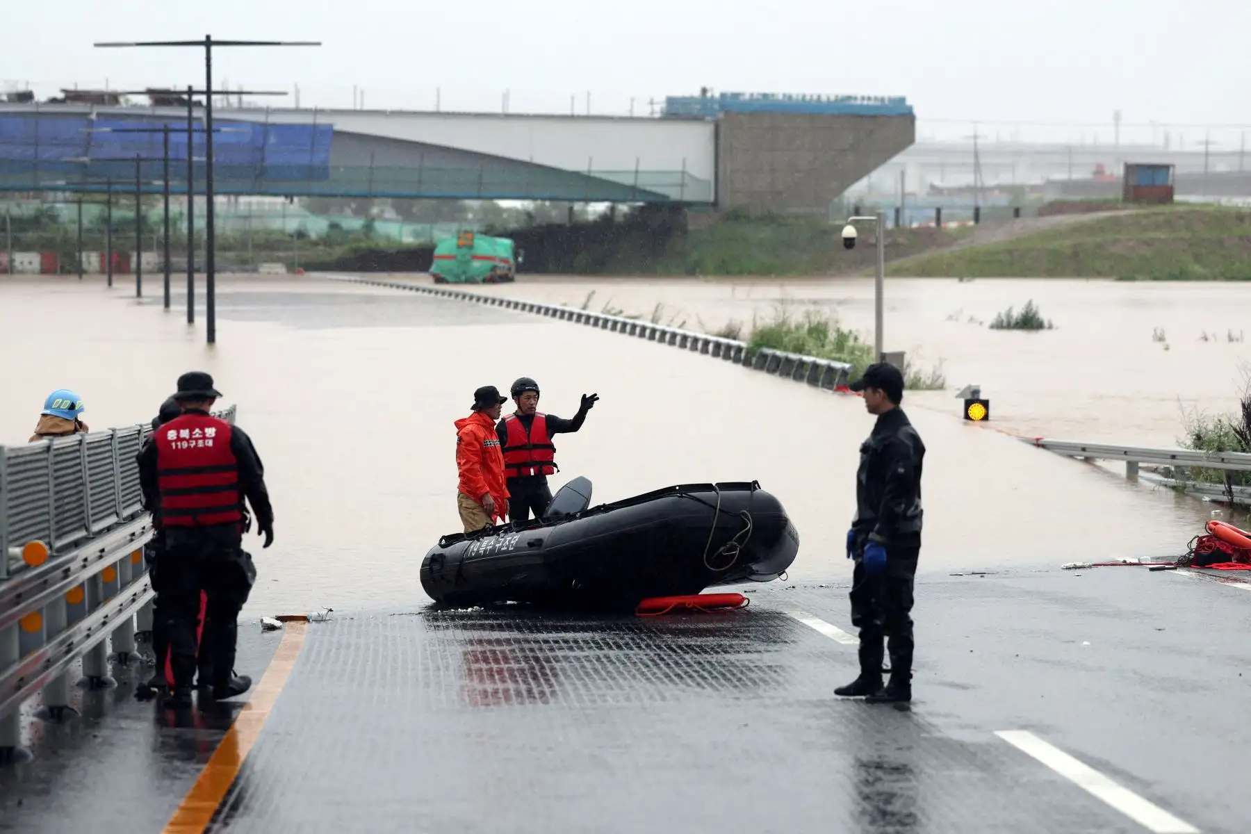 Los trabajadores de emergencia de Corea del Sur buscan sobrevivientes en una carretera inundada que conduce a un túnel subterráneo donde unos 19 automóviles quedaron atrapados por las aguas de la inundación después de las fuertes lluvias en Cheongju el 15 de julio de 2023. Al menos 22 personas han muerto y 14 más están desaparecidas después de las fuertes lluvias. provocó inundaciones y deslizamientos de tierra en Corea del Sur, dijeron las autoridades el 15 de julio, y se ordenó a miles más que evacuaran s