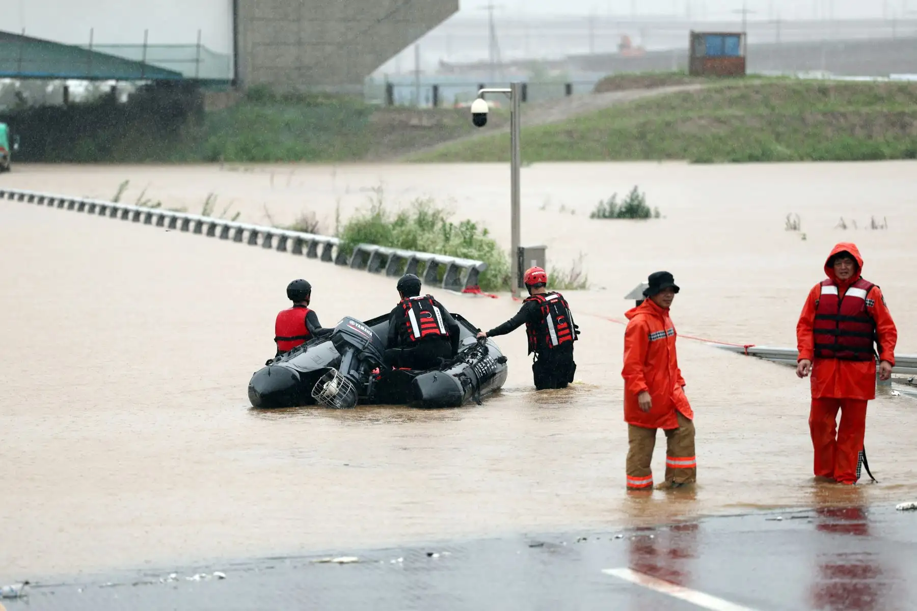 Los trabajadores de emergencia de Corea del Sur buscan sobrevivientes en una carretera inundada que conduce a un túnel subterráneo donde unos 19 automóviles quedaron atrapados por las aguas de la inundación después de las fuertes lluvias en Cheongju el 15 de julio de 2023. Al menos 22 personas han muerto y 14 más están desaparecidas después de las fuertes lluvias. provocó inundaciones y deslizamientos de tierra en Corea del Sur, dijeron las autoridades el 15 de julio, y se ordenó a miles más que evacuaran s