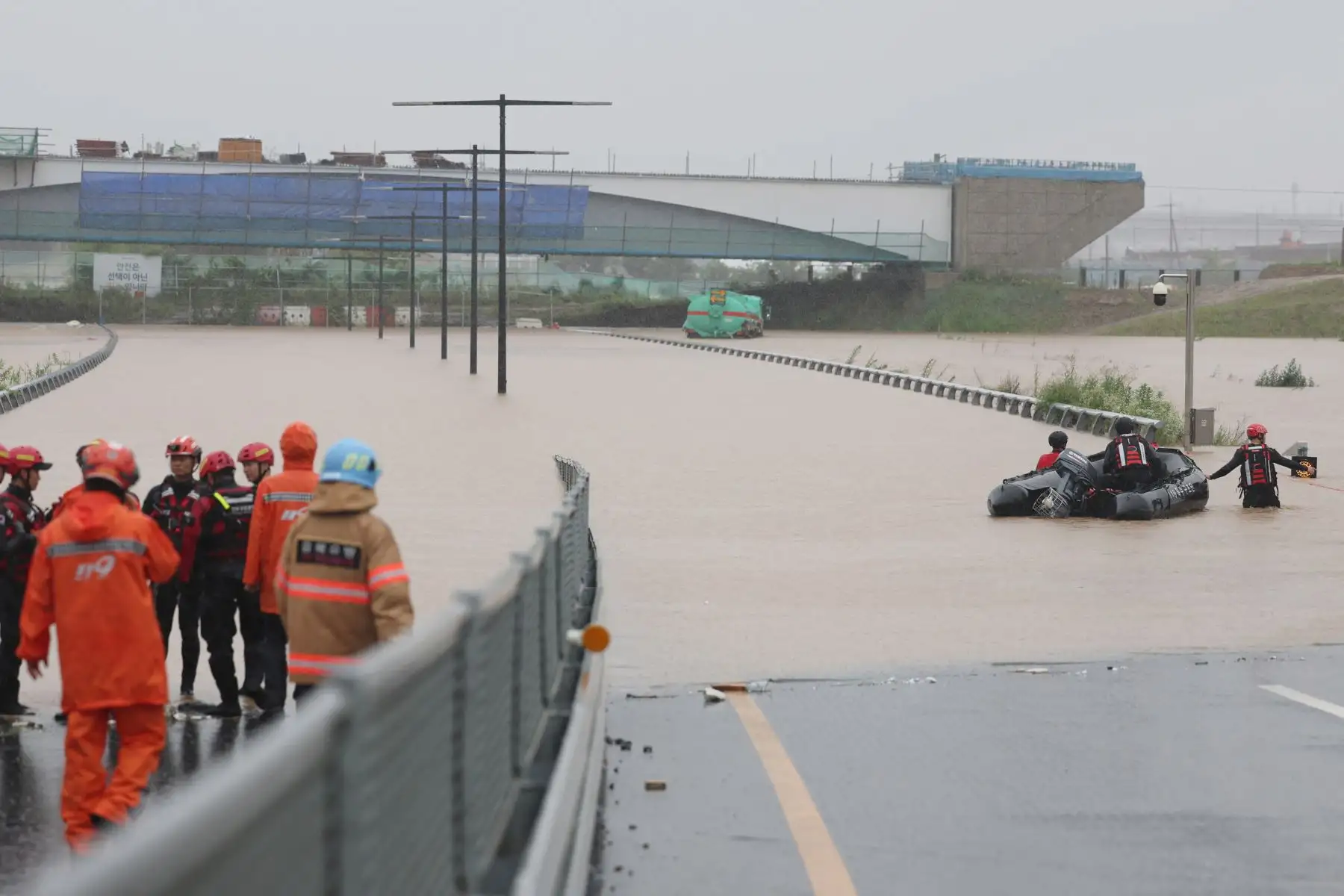 Los trabajadores de emergencia de Corea del Sur buscan sobrevivientes en una carretera inundada que conduce a un túnel subterráneo donde unos 19 automóviles quedaron atrapados por las aguas de la inundación después de las fuertes lluvias en Cheongju el 15 de julio de 2023. Al menos 22 personas han muerto y 14 más están desaparecidas después de las fuertes lluvias. provocó inundaciones y deslizamientos de tierra en Corea del Sur, dijeron las autoridades el 15 de julio, y se ordenó a miles más que evacuaran s