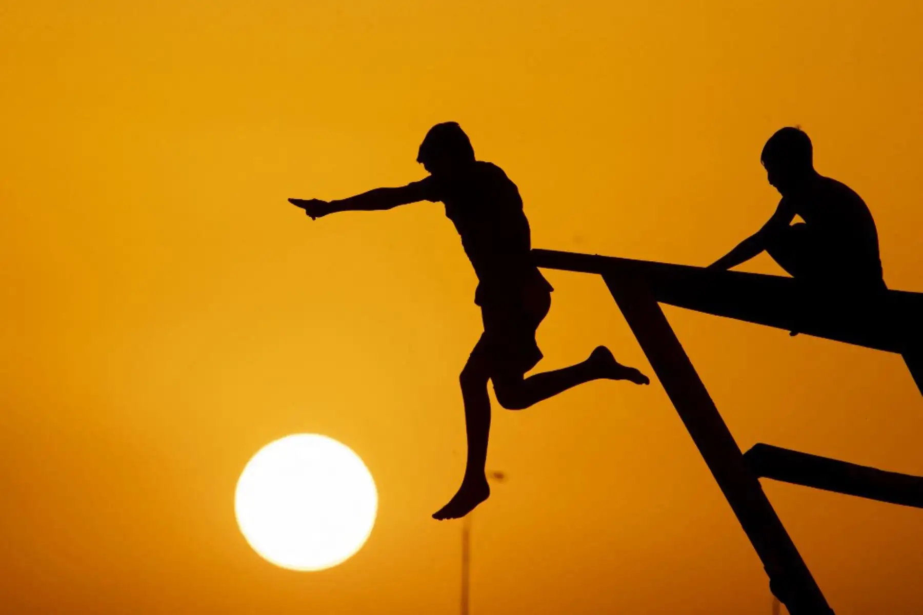 Jóvenes se sumergen en el canal Shatt al-Arab para escapar del calor en la ciudad de Basora, en el sur de Irak. Foto: AFP