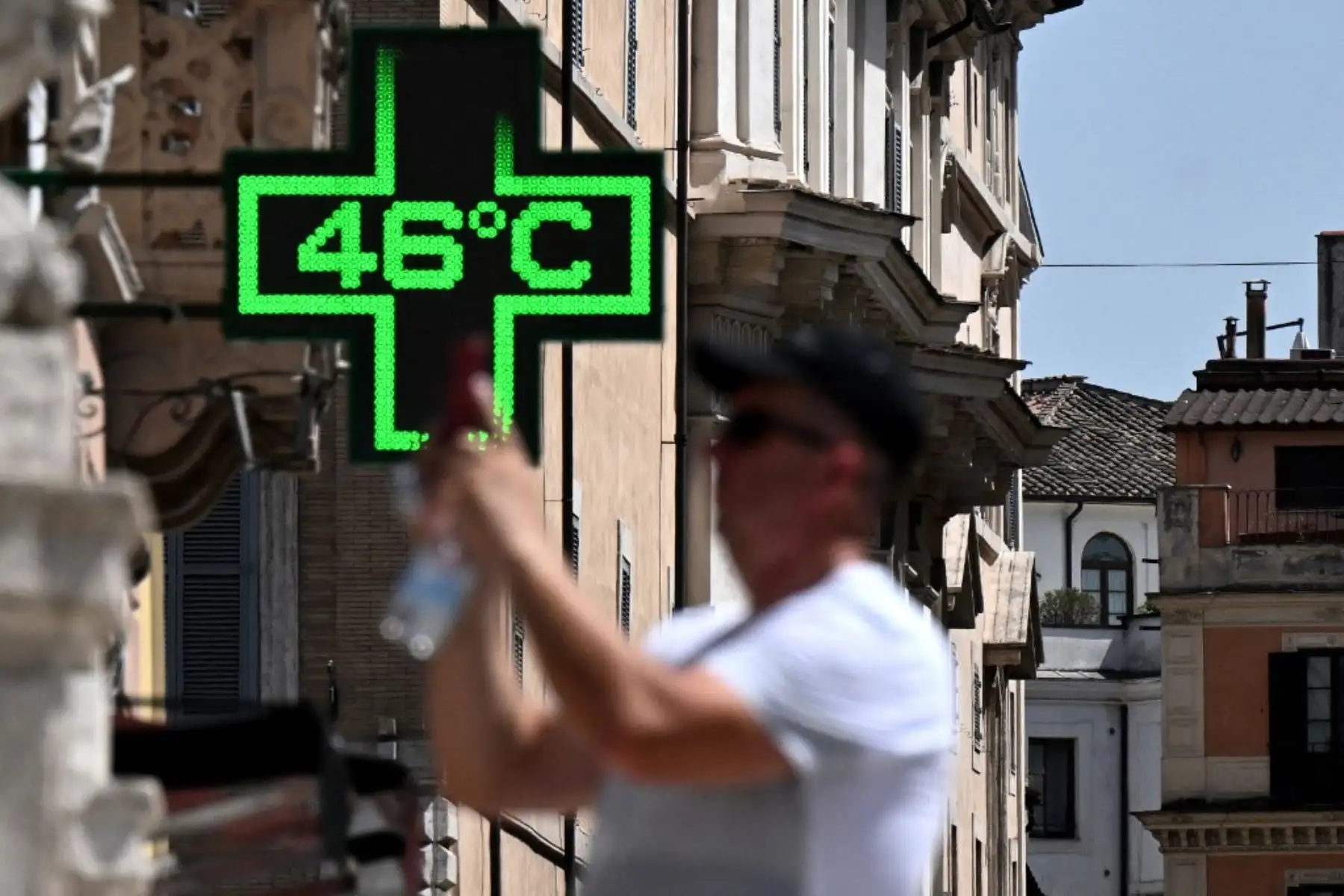 Un turista toma una foto frente al letrero de una farmacia que indica la temperatura exterior actual de 46 grados centígrados cerca de la Scalinata di Trinita dei Monti (Escalinata Española) en Roma. Foto: AFP