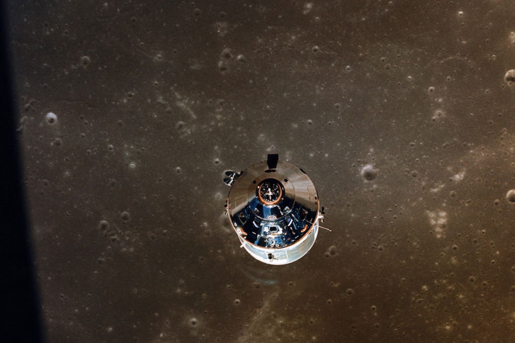 Fotografía tomada por el Módulo Lunar (LM) de los Módulos de Comando y Servicio del Apolo XI en órbita lunar durante la misión de aterrizaje. El terreno lunar debajo es la porción noreste del Mar de la Fertilidad. Foto de la NASA / AFP