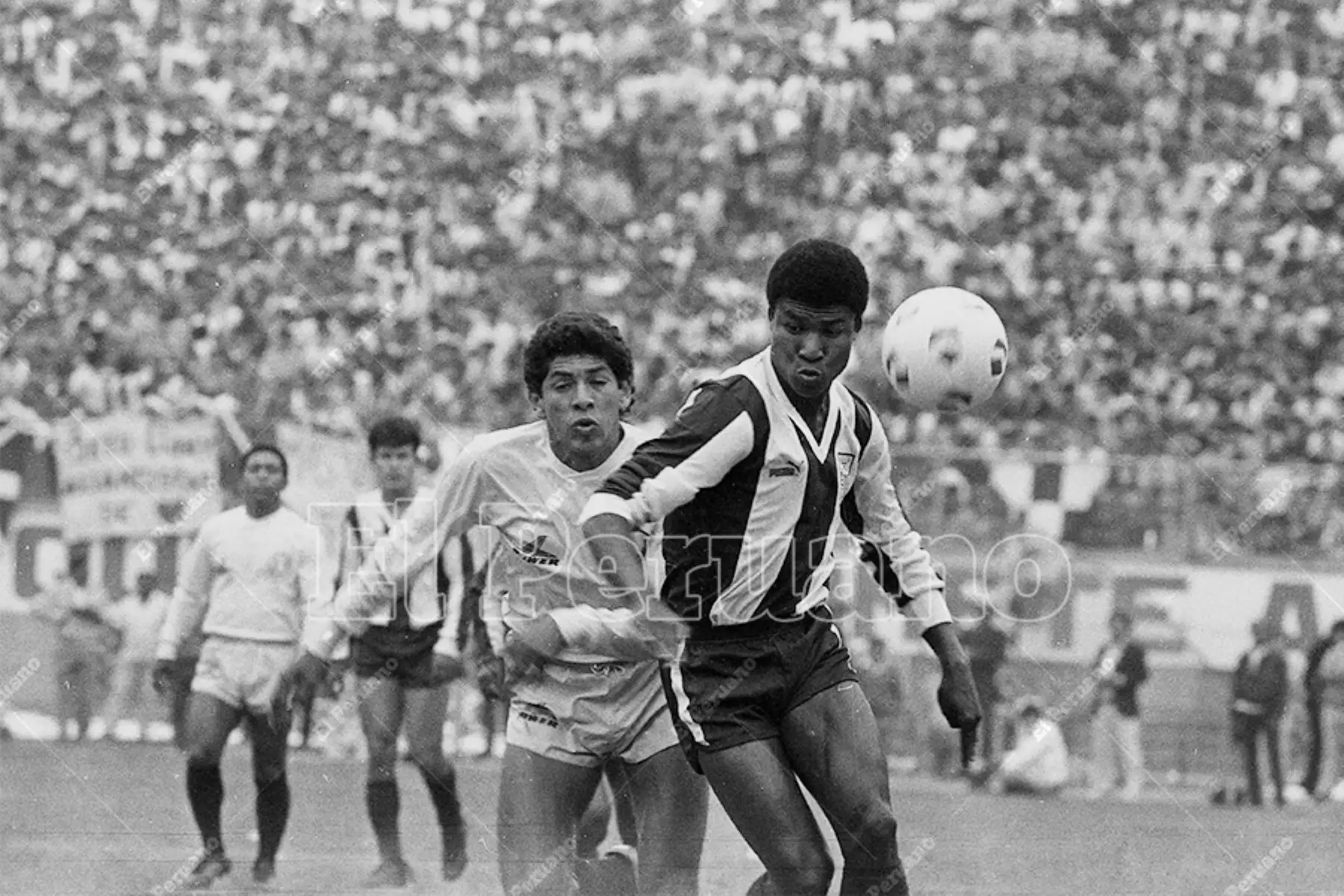 Lima - 1 noviembre 1987 / El delantero aliancista Luis Escobar supera a sus marcadores en el encuentro entre Alianza Lima y Universitario de Deportes. El cuadro aliancista ganó el clásico 1-0 con gol del "Potrillo" Escobar. Foto: Archivo Histórico de El Peruano / Rómulo Luján