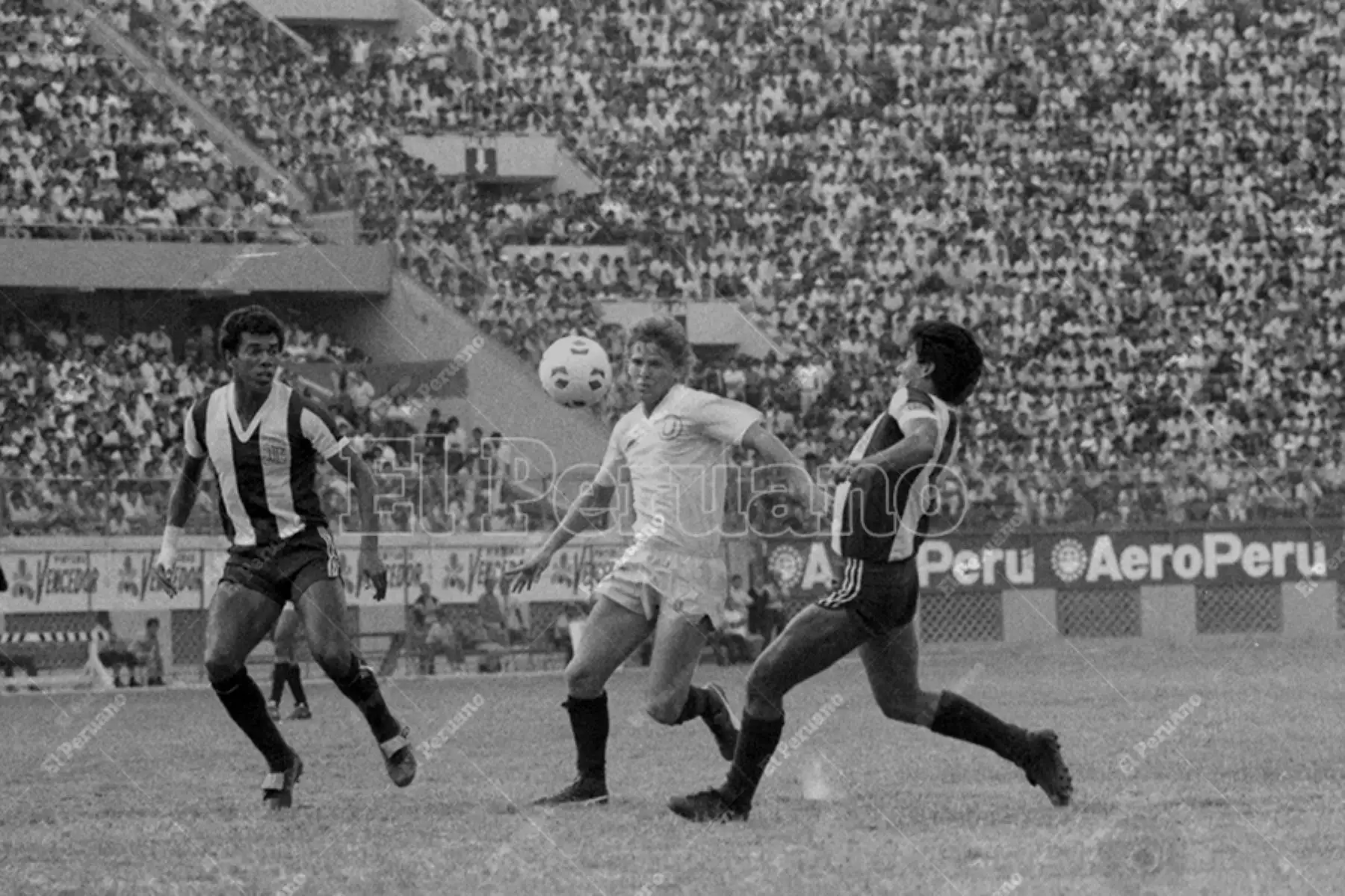 Lima - 22 diciembre 1985 / El mediocampista Jaime Drago intenta superar a dos marcadores. Universitario de Deportes derrotó 1-0 a Alianza Lima en el clásico del fútbol peruano. Foto: Archivo Histórico de El Peruano / Américo Alburquerque