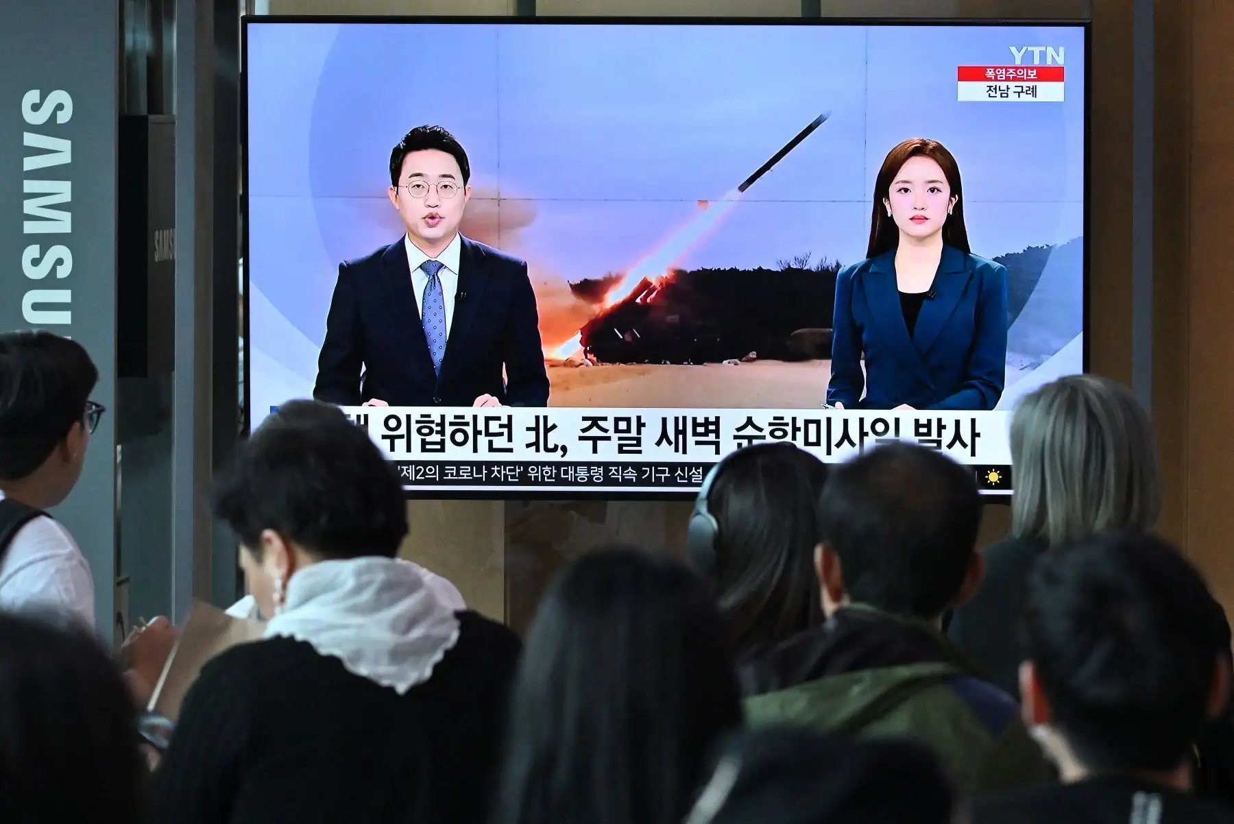 La gente mira una pantalla de televisión que muestra una transmisión de noticias con imágenes de archivo de una prueba de misiles de Corea del Norte, en una estación de tren en Seúl el 22 de julio de 2023. Corea del Norte ha disparado "varios misiles de crucero" al Mar Amarillo entre China y la península de Corea, dijo el Estado Mayor Conjunto de Corea del Sur en julio de 2023. Foto: AFP