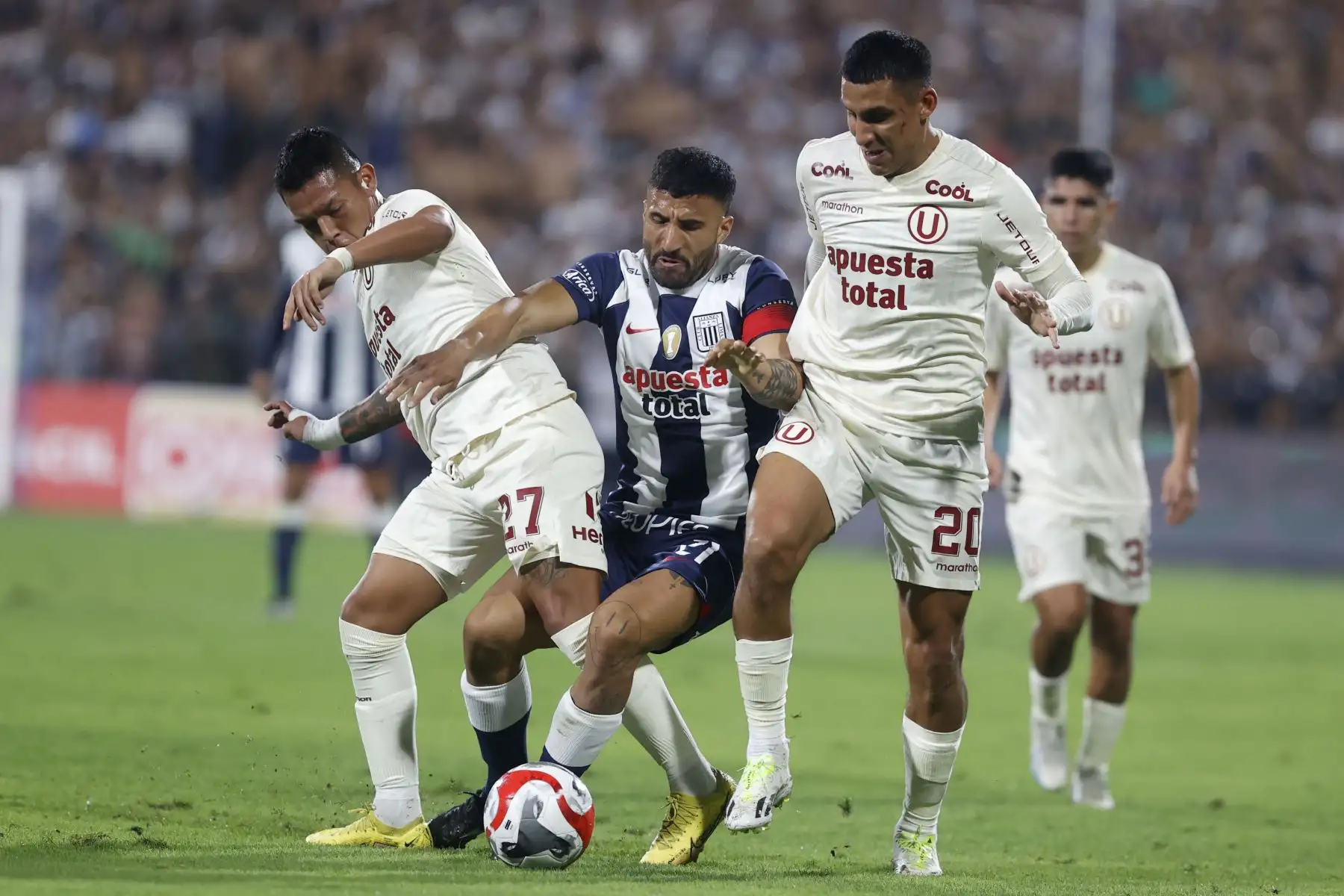 Los  jugadores de Universitario de Deportes, Carlos Cabanillas y Alex Valera disputan el balón ante el jugador de Alianza Lima en el super clásico por la fecha 5 de la Clausura en el estadio Alejandro Villanueva.
Foto: ANDINA/ Vidal Tarqui