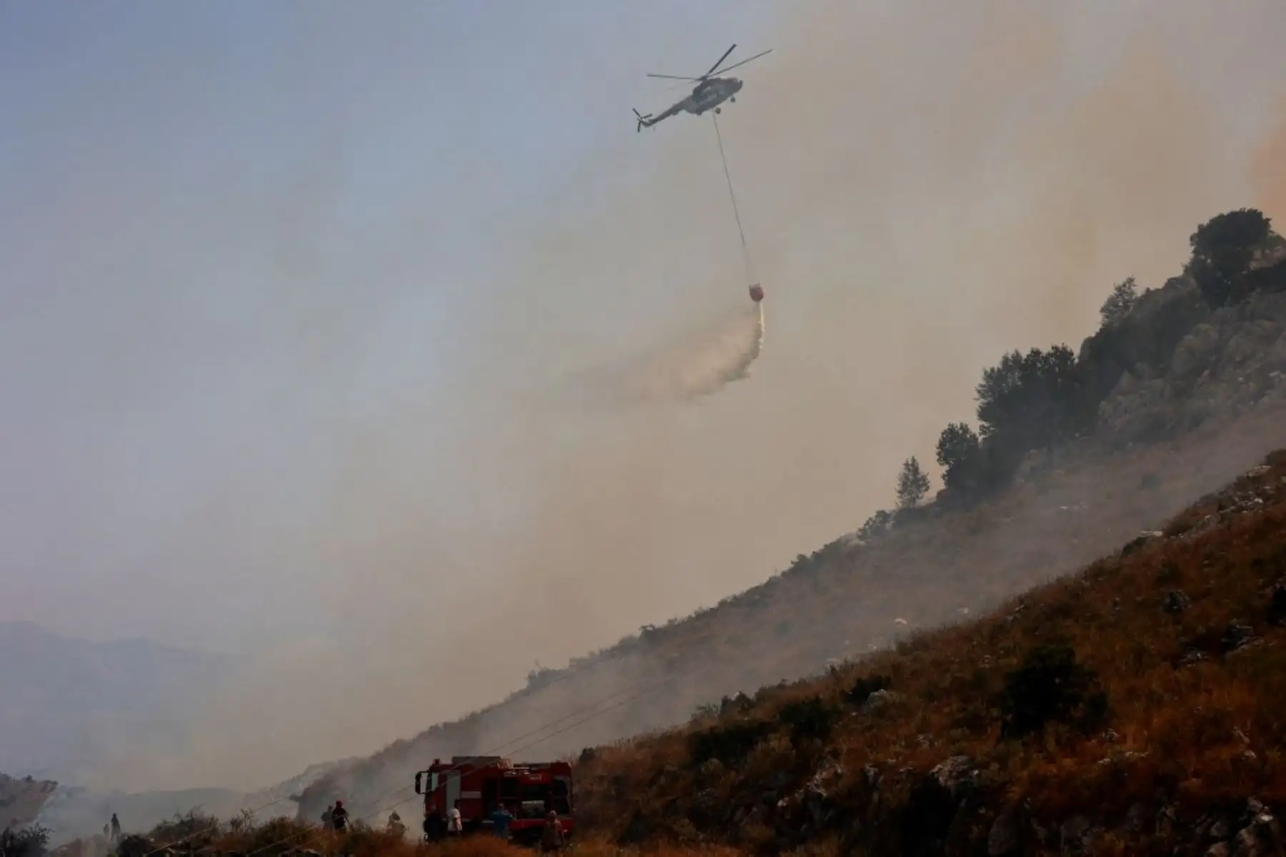 Un helicóptero arroja agua sobre los incendios en la parte norte de la isla griega de Corfú. Las autoridades evacuaron a casi 2500 personas de la isla griega de Corfú el 24 de julio de 2023, ya que la nación azotada por el calor estaba "en guerra" con varios incendios forestales. Foto: AFP