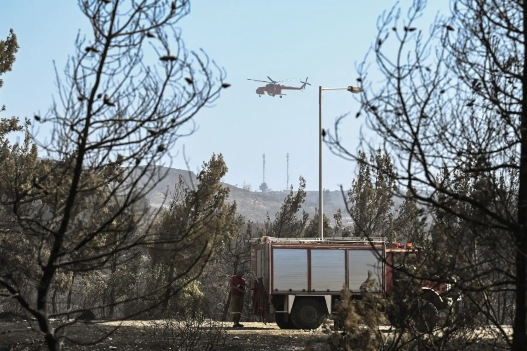 Un helicóptero arroja agua sobre los incendios en la parte norte de la isla griega de Corfú. Las autoridades evacuaron a casi 2500 personas de la isla griega de Corfú el 24 de julio de 2023, ya que la nación azotada por el calor estaba "en guerra" con varios incendios forestales. Foto: AFP