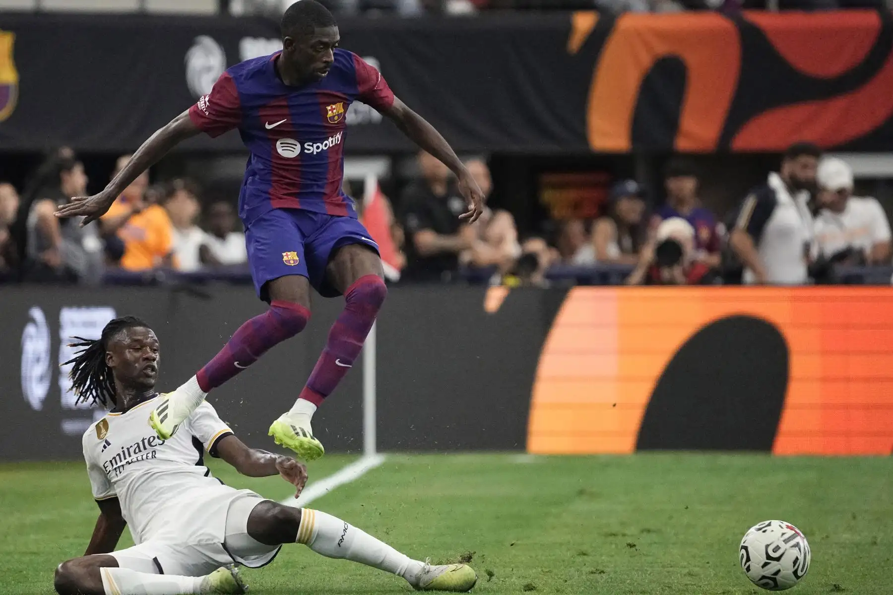 Ousmane Dembélé  del FC Barcelona salta sobre Eduardo Camavinga 12 del Real Madrid durante la primera mitad de un partido amistoso de pretemporada en el AT&T Stadium  en Arlington, Texas. Foto: ANDINA/AFP