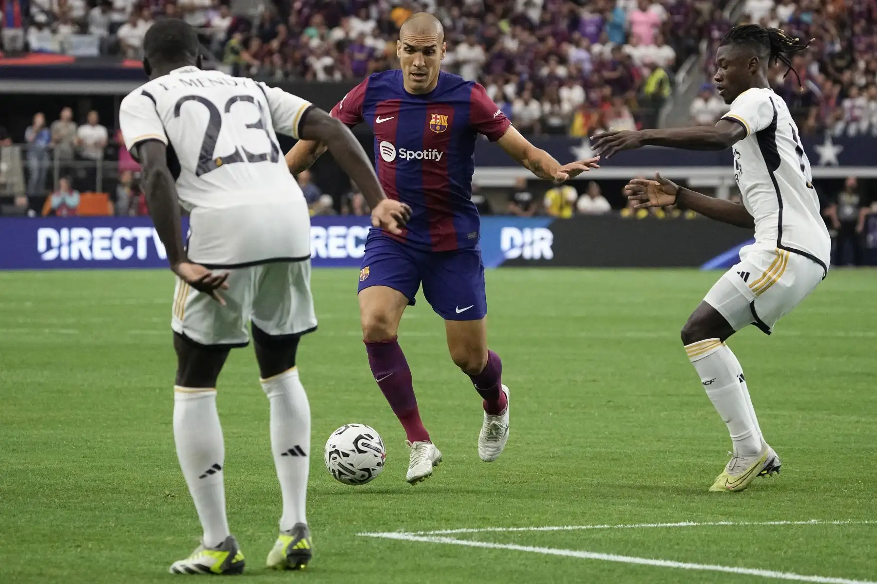 Oriol Romeu 18 del FC Barcelona controla el balón entre Ferland Mendy 23 del Real Madrid y Eduardo Camavinga 12 durante el partido amistoso de pretemporada entre el FC Barcelona y el Real Madrid en el AT&T Stadium  en Arlington, Texas. Foto:ANDINA/ AFP