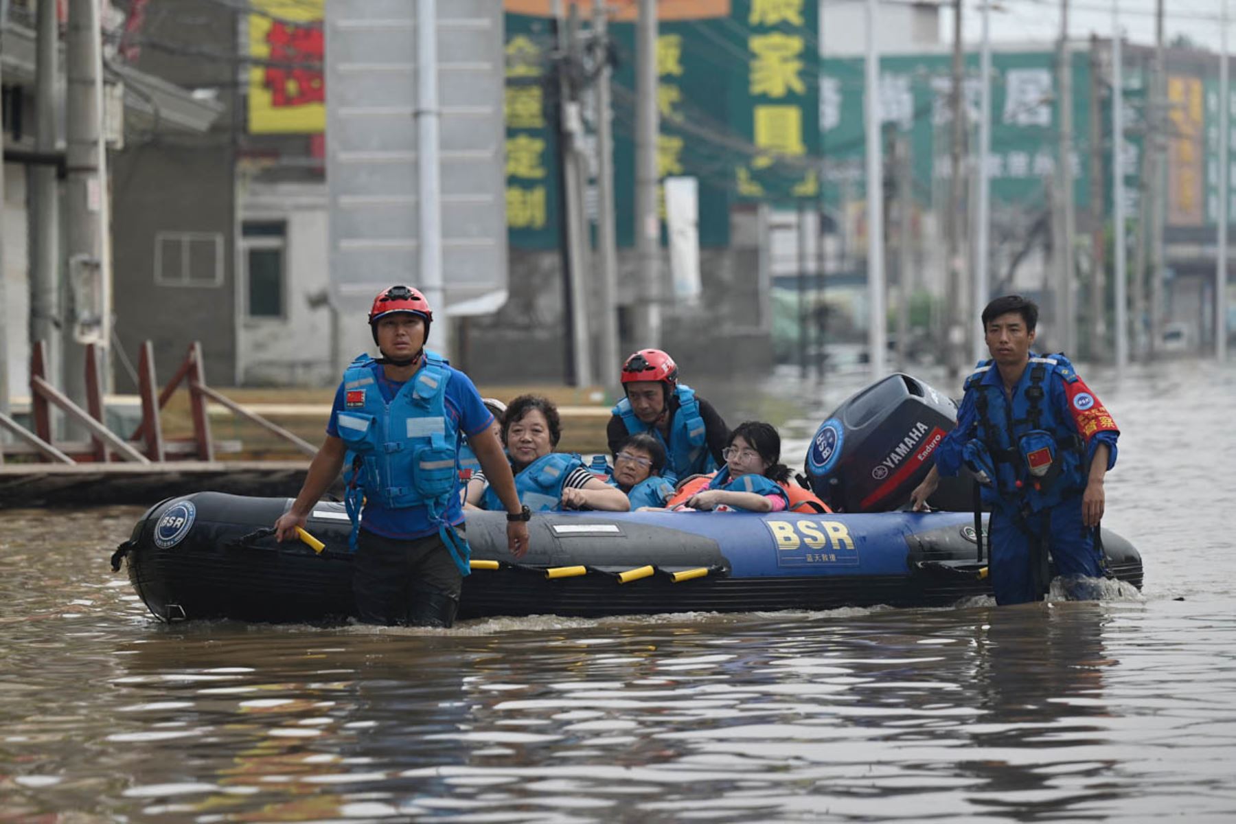 El personal del equipo de rescate camina por una carretera inundada mientras evacua a los residentes luego de las fuertes lluvias en Zhuozhou, en la provincia de Hebei, en el norte de China. Foto: AFP