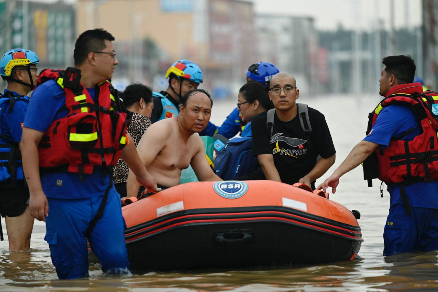 El personal del equipo de rescate camina por una carretera inundada mientras evacua a los residentes luego de las fuertes lluvias en Zhuozhou, en la provincia de Hebei, en el norte de China. Foto: AFP