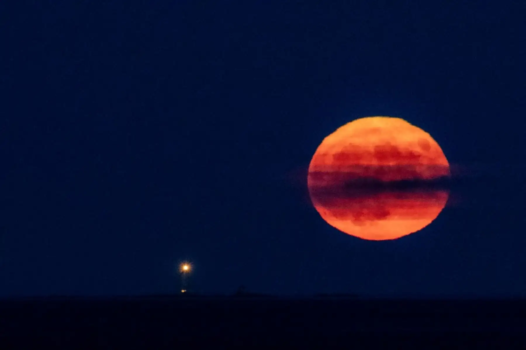 La superluna del esturión se eleva sobre The Graves Lighthouse en la bahía de Massachusetts. Foto: AFP