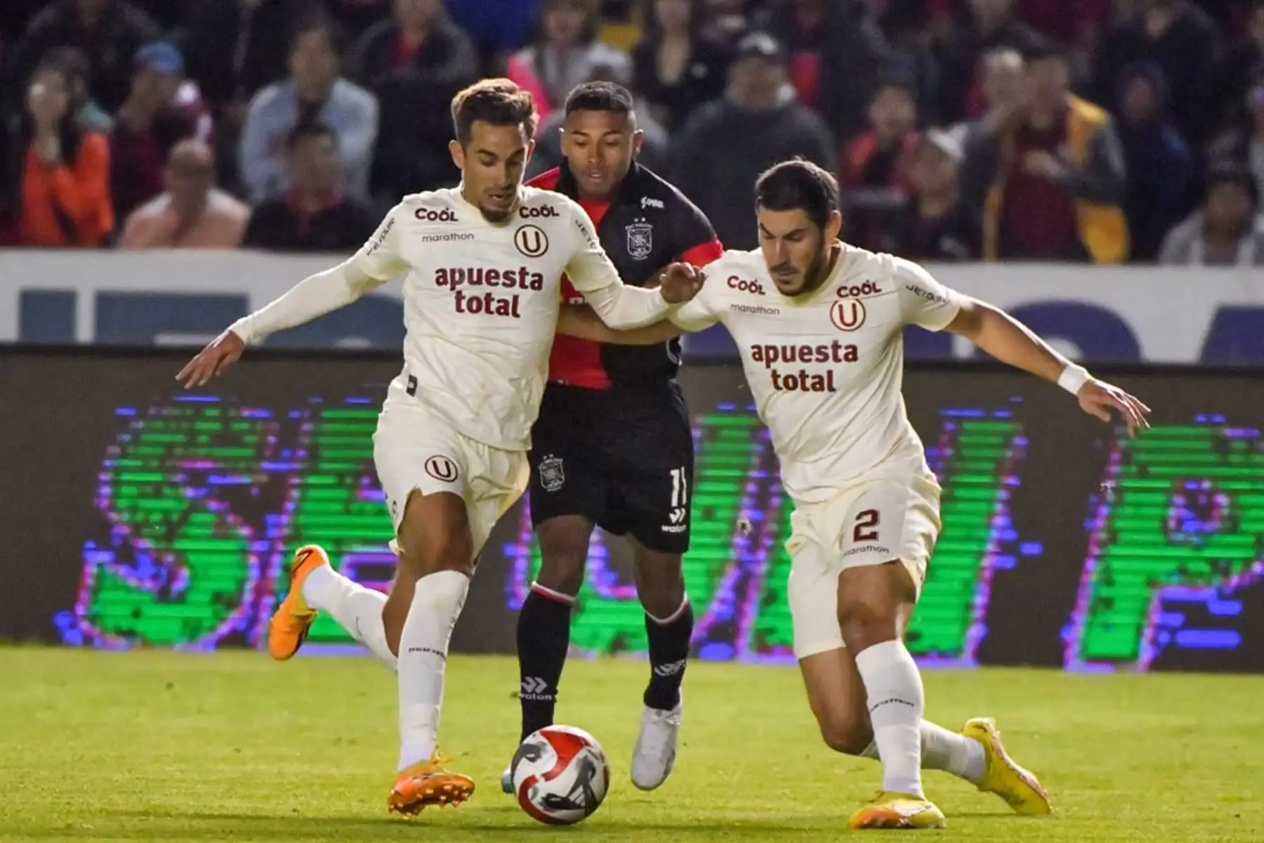 Marco Saravia y Pérez Guedes de Universitario de Deportes disputan el balón ante el jugador de FBC Melgar  por la fecha 7 del Torneo Clausura 2023 en el estadio Monumental UNSA. 
Foto: cortesía Diego Ramos