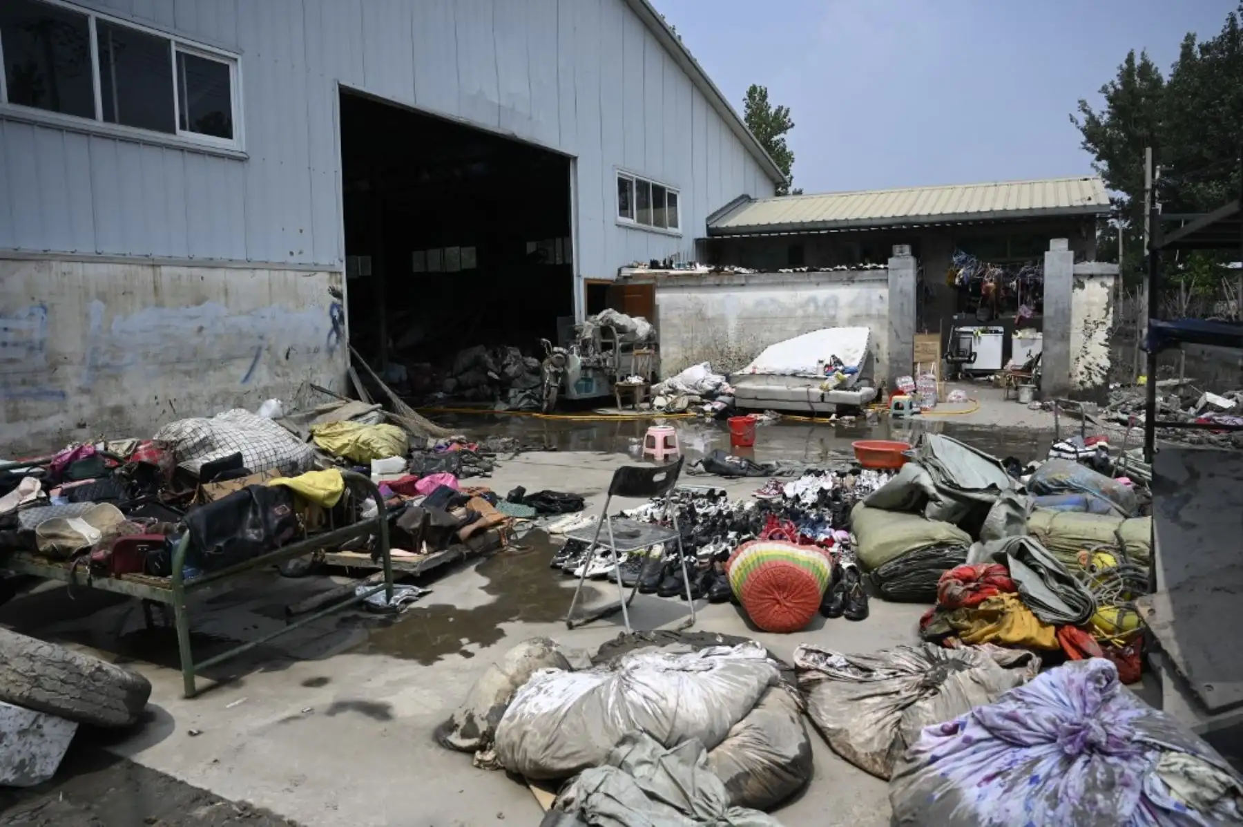 Los bolsos y los zapatos se dejan secar fuera de un almacén después de las inundaciones en una aldea después de las fuertes lluvias en la ciudad de Zhuozhou, en la provincia de Hebei, en el norte de China. Foto: AFP