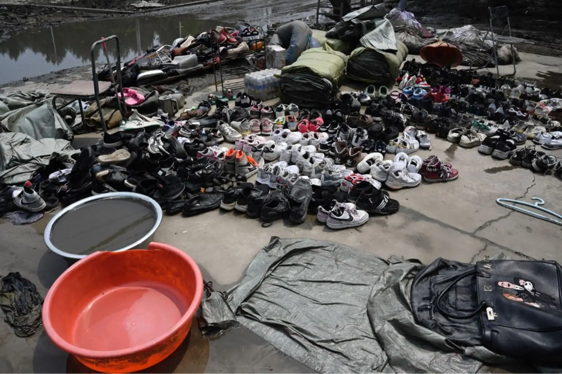 Los bolsos y los zapatos se dejan secar fuera de un almacén después de las inundaciones en una aldea después de las fuertes lluvias en la ciudad de Zhuozhou, en la provincia de Hebei, en el norte de China. Foto: AFP