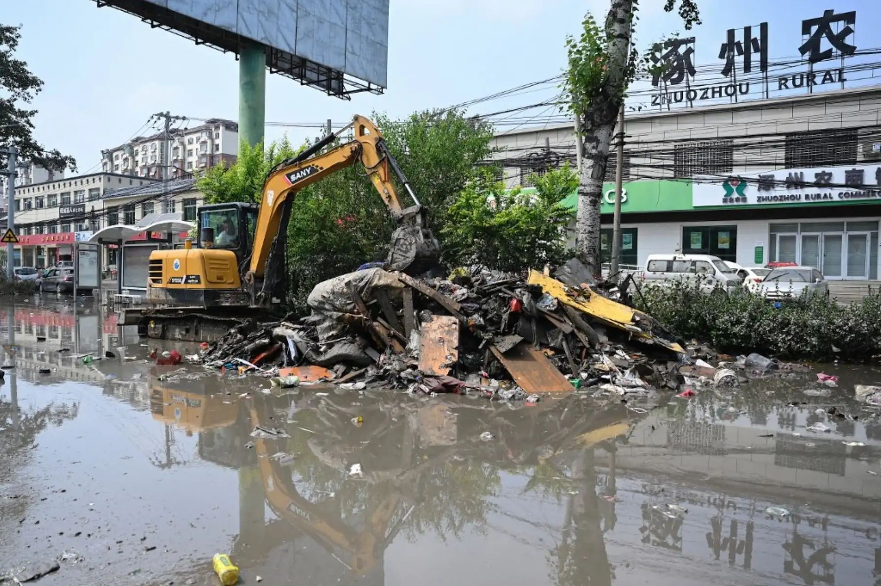 Un trabajador limpia los escombros de una calle después de las inundaciones causadas por las fuertes lluvias en la ciudad de Zhuozhou, en la provincia de Hebei, en el norte de China. Foto: AFP