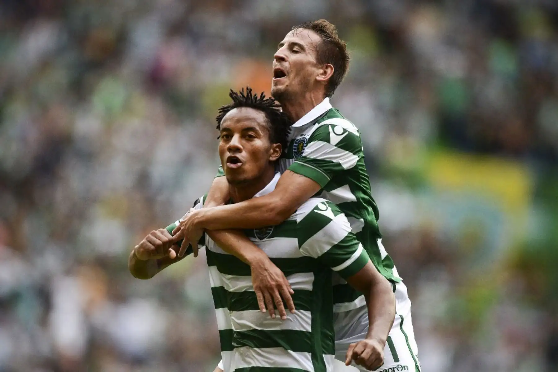 El delantero peruano del Sporting Andre Carrillo celebra con su compañero el defensor del Sporting Joao Pereira después de anotar contra Pacos de Ferreira durante el partido de fútbol de la liga portuguesa Sporting CP vs FC Pacos de Ferreira en el estadio José Alvalade en Lisboa el 22 de agosto de 2015. Foto: ANDINA/AFP